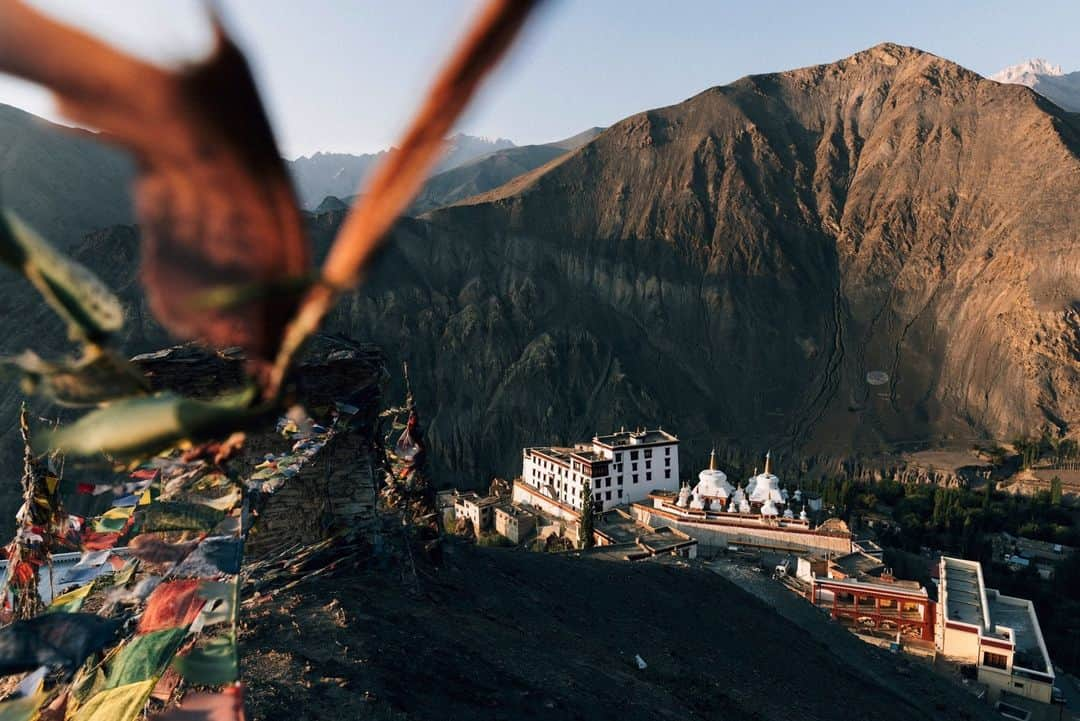 National Geographic Travelのインスタグラム：「Photo by @jodymacdonaldphoto | Sitting above Lamayuru Monastery at sunrise is an ethereal experience. As the first rays of the sun gently kiss the rugged landscape, the monastery emerges from the shadows, revealing its ancient splendor. The air is crisp, carrying a serene stillness broken only by the distant prayers and the fluttering of prayer flags that seek to spread peace, compassion, and wisdom across the world.   Follow me @jodymacdonaldphoto to see more images from my travels around the world.」