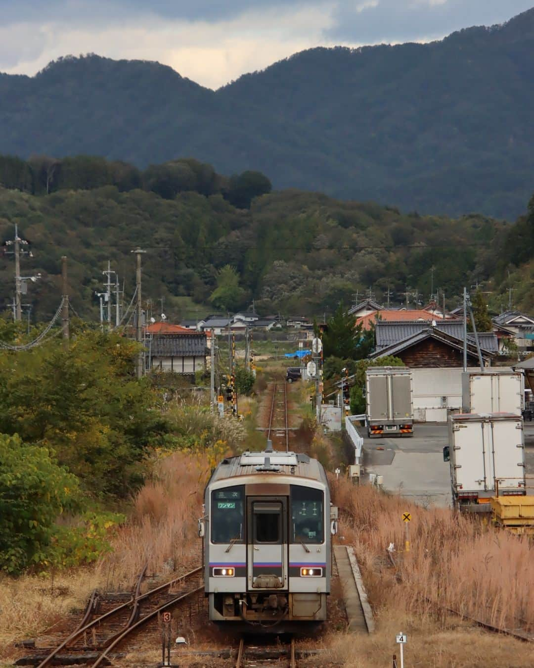 徳永ゆうきのインスタグラム：「. . 山々に囲まれてゆっくりと。 . -2023.10.21- . #鉄道写真 #撮り鉄 #鉄道好き #JR西日本 #芸備線 #備後庄原駅 #キハ120系 #気動車 #普通 #ワンマン #三次行き」