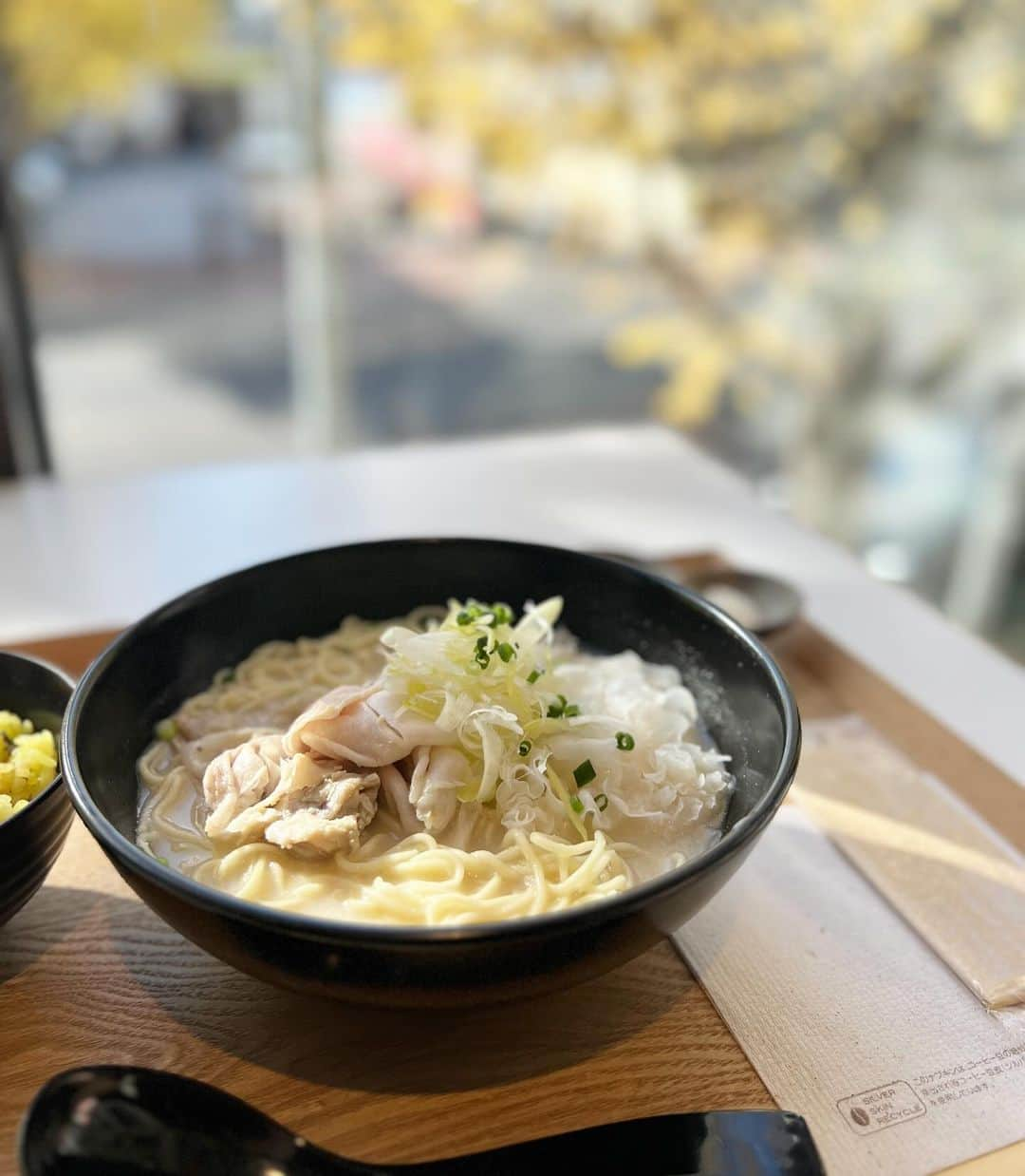 本谷亜紀のインスタグラム：「期間限定でオリジナル“フレンチ熊本ラーメン“が登場！  📍MuSuBu　八芳園 🚉白金台  八芳園の運営している白金台のポップアップ型ショールーム「MuSuBu」で、熊本WINTERフェアを開催中とのことで ご招待いただきオリジナルラーメンを食べてきたよ🍜  熊本とんこつラーメンをベースにフレンチを掛け合わせたラーメンは塩・醤油・味噌から選べる！ 今回選んだ塩とんこつはなんとニンニクとアーモンドベース👀 そのまま食べるととてもクリーミーなスープで、パンチが欲しい時は別添えのマー油を入れることで ガッツリした味わいになるのも美味しかった！  セットのからし蓮根と高菜を混ぜ込んだターメリックライスは、最後に豚骨スープをかけてリゾット風に。 ドリンクもセットで1600円です！  デザートには熊本産まるごとみかんのパフェも🍊こちらは1200円！ みかんのゼリーやランボワーズソース、ピスタチオのメレンゲ、マスカルポーネのムースが重なっててリッチな味わい！  ここのスペースはちょうどプラチナ通りの紅葉がよく見えて、気持ちよく食事ができます！ 12月3日までの限定ですので気になる方はお早めに🏃‍♀️ #熊本ラーメン　#MuSuBu八芳園　#白金ランチ　#pr  #ラーメン #らーめん #麺スタグラム #つけ麺 #ランチ #中華そば #🍜　#ラーメン女子　#ラーメンランチ」