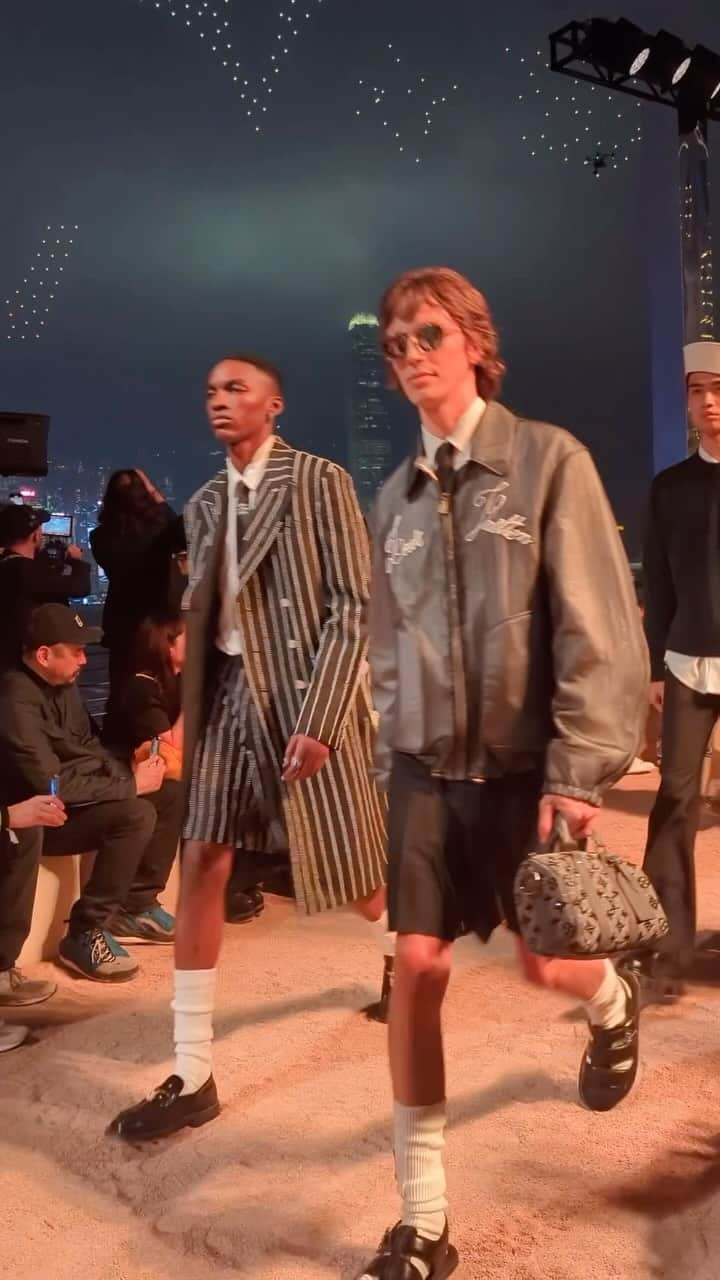 Vogue Runwayのインスタグラム：「For @LouisVuitton’s pre-fall collection, @Pharrell Williams followed up his knockout spring 2024 show in Paris this past summer with a blowout outdoor runway presentation in Hong Kong. Taking over the city’s famous Avenue of Stars overlooking the Victoria Harbor, Williams leaned into a maritime theme for his sophomore collection for the house. There were dandy sailor hats and tailoring, après-surf shorts and jackets, Hawaiian-like florals, and even a ukulele. Not one to do away with some spectacle, Williams closed his show with a swarm of illuminated drones hovering above his runway. Discover the collection at the link in bio. Runway video by @luke_leitch」