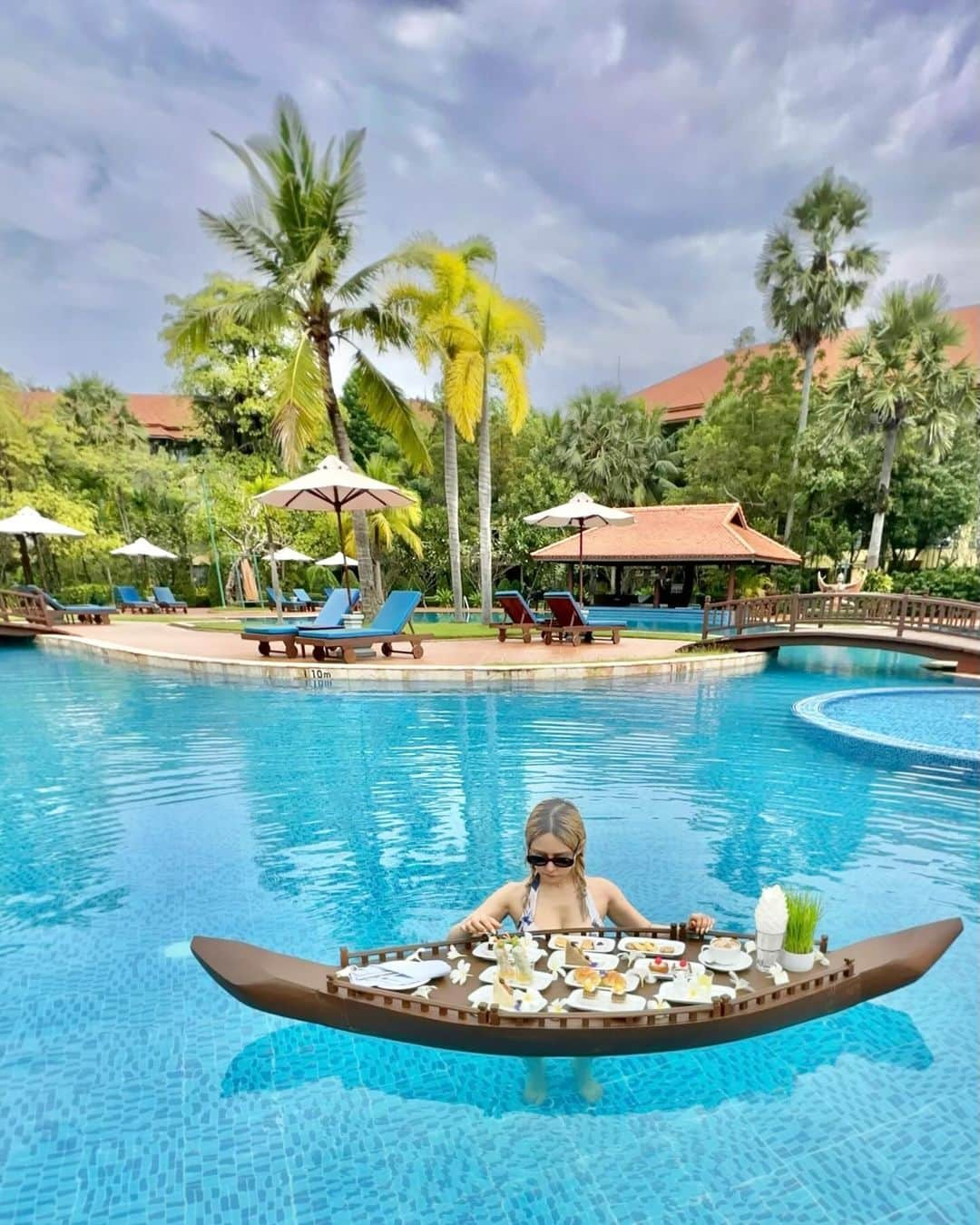 YuhKawasakiのインスタグラム：「📍Angkor Palace Resort&Spa   プールでアフタヌーンティー🫖🍴🧁 昼間は遺跡巡りされる方が多いので ホテルのプールは貸切🫶  1人でもアフタヌーンティー出来るか聞いたら OKとのことでしたが 普通に2人分出てきた模様笑  これで約16USドルなので2人でしたら 1人あたりたったの8USドル💵 日本だとこのお値段でこの体験は できないね😍  プールにプカプカ浮きながら食べるのって めちゃくちゃ楽しいんです🍴笑 ： ： ： ： ： ： ： #angkorpalaceresortandspa #floatinghitea#floatingafternoontea #floatingbreakfast #cambodiatravel #cambodiahotel #greenresort #siemreaphotel #カンボジアホテル#シェムリアップホテル#フローティングアフタヌーンティー#フローティングハイティー#フローティングブレックファースト #カンボジア旅行 #カンボジア料理 #カンボジア女子旅 #カンボジアカフェ #トランカー#シェムリアップ旅行 #シェムリアップ観光 #シェムリアップカフェ #プールでのんびり #ホカンスグラム#リゾートホテル #東南アジア旅行 #angkorpalace #ハイティー#アフタヌーンティーのある暮らし #タビジョ#旅スタグラム」