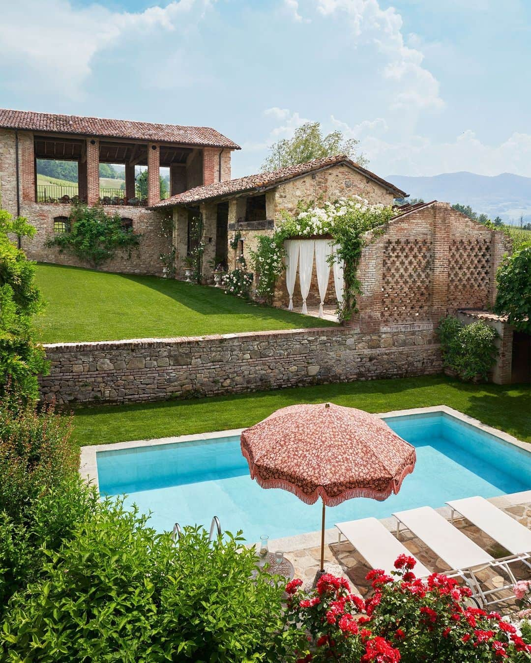 ELLE DECORのインスタグラム：「Poolside is my best side—though we’d argue that there’s no bad angle in this Eden-like backyard moment near Piacenza, Italy. Paolo Castellarin (@paolo.castellarin) and his husband, Didier Bonnin, found the property in 2018. They had been searching for a getaway within an hour or so of Milan, where they live—somewhere they could easily escape with friends on the weekend to wander the countryside or take a dip in the pool when temperatures soared. Here, Castellarin endeavored to retain the home’s historical aura while injecting his own eclectic style. What are you waiting for? The water’s great! 💧  Click the link in the bio to tour the rest of this countryside retreat, as featured in our Winter 2024 issue. Written by @lauramaytodd. Photographed by @francescodolfophotography.」