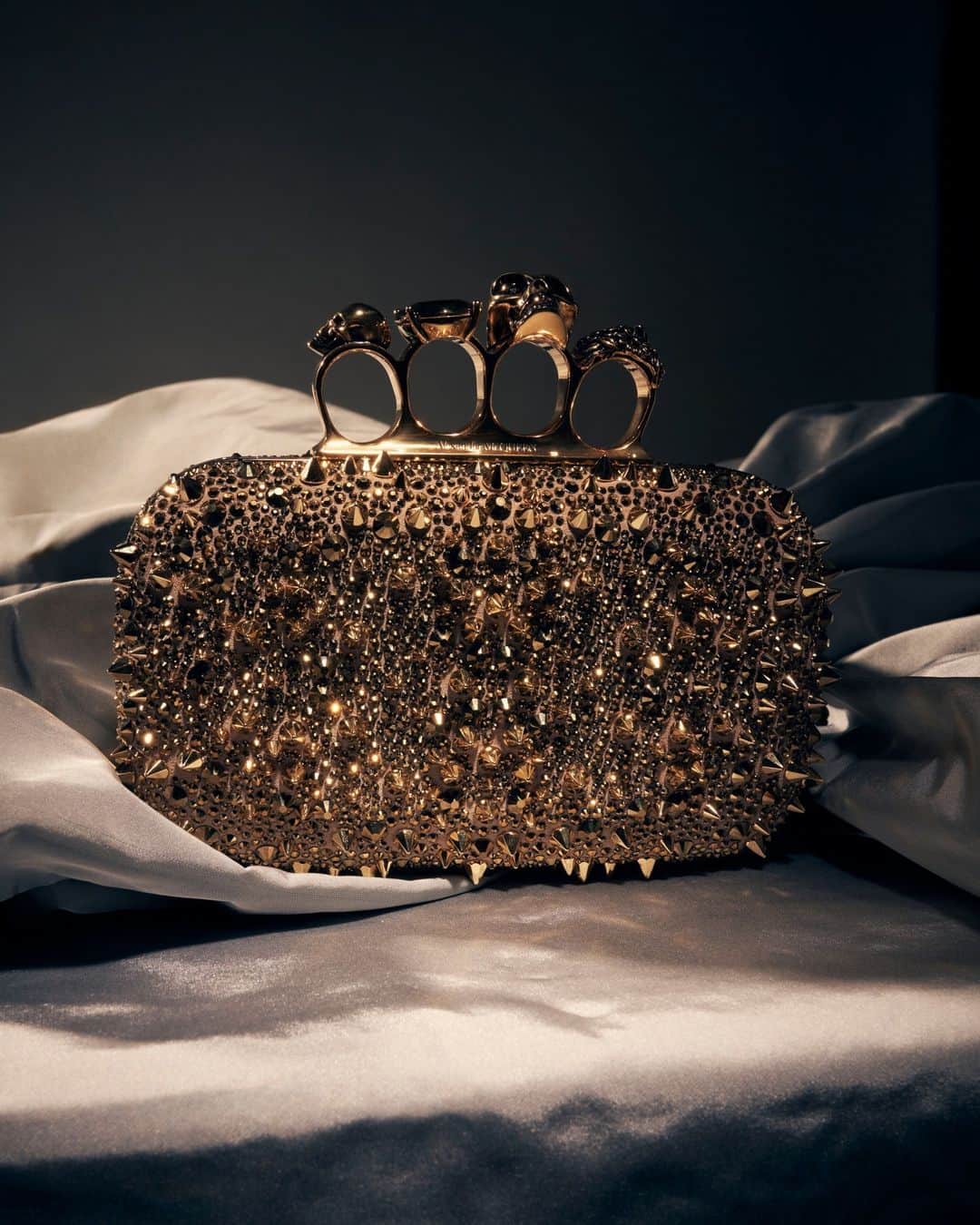 アレキサンダー・マックイーンのインスタグラム：「The #McQueenKnuckle clutch with gold crystal embroidery, from the #McQueenGifts collection.⁣ ⁣ Discover the collection via the link in bio.⁣ ⁣ Photographed by @maximepoiblanc」