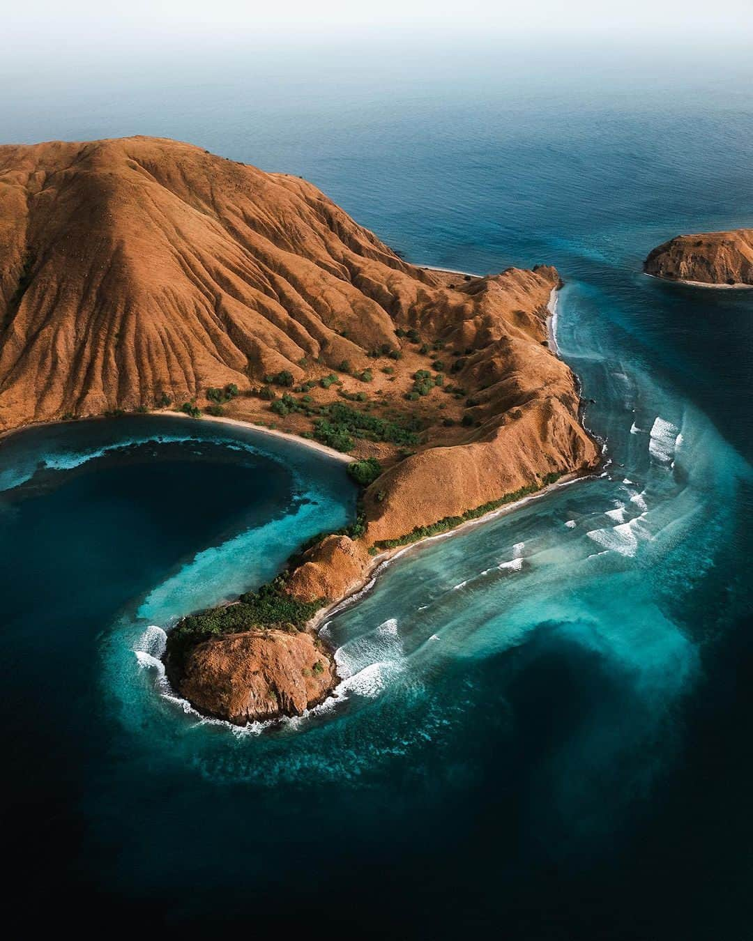 Coronaのインスタグラム：「From this perspective, you can see that the Komodo National Park is uniquely stunning. Komodo Island's landscape hosts dramatic contrasts between rugged hillsides of dry savanna, pockets of green, and brilliant white sandy beaches. ⁣ ⁣ Visitors who want to see the famed komodo dragons alongside the idyllic landscapes can head ashore, trek around the volcanic landscapes of Padar Island, and enjoy multiple stops to swim and snorkel including Manta Point and Pink Beach. ⁣ ⁣ #ThisIsLiving ⁣ ⁣ 📷: @jonashornehoj⁣ ⁣ #Indonesia」