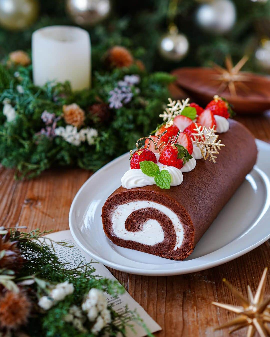 Ayaのインスタグラム：「いちごのカカオロール🍓  おはようございます😊  いつかのおやつ。  ロールケーキは、我が家で人気のおやつで、1番作るおやつでもあります。  なかでも1番人気はヴァローナカカオパウダーと米粉で作る生地に生クリームの組み合わせ‼️  今回はいちごもプラス🍓  黒生地に白クリームそしていちごのコントラストが好きです😆  そんないつものおやつも、毎年恒例のななちゃん　@nanako989870 お手製のリースをスタイリングにつかい、一気にクリスマス仕様に🥺✨  毎年アップデートされていくななちゃんのリース✨今年はミニスワッグまで💓  届いた箱を開けた瞬間、あまりの素敵さに思わず声がでます🤣❣️  花材の組み合わせやバランスもよくて可愛い💕  到着してしばらくは香りもすごくて✨ 幸せな香りがリビングに広がってました😍  ななちゃんのリースのおかげで、毎年クリスマスのテーブルがよりクリスマスらしくなって、撮影も楽しい😆💓  今年もクリスマスまでバンバン使わせてもらうね🥺✨✨  他にも可愛い木製のトレーやプレゼントまで🥺🙏  本当に素敵なプレゼントをありがとう🥰✨  そして、今日はななちゃんのお誕生日〜🎂🎊  ななちゃん、お誕生日おめでとう❤️  素敵な一年になりますように✨  #手作りおやつ #手作りロールケーキ#カカオロールケーキ#クリスマスリース#クリスマススワッグ#クリスマスプレゼント#素敵便#フーディーテーブル#マカロニメイト#コッタ  #homemade#homemadecake#rollcake#foodporn#foodie#foodstagram#Christmaswreath#wreath」