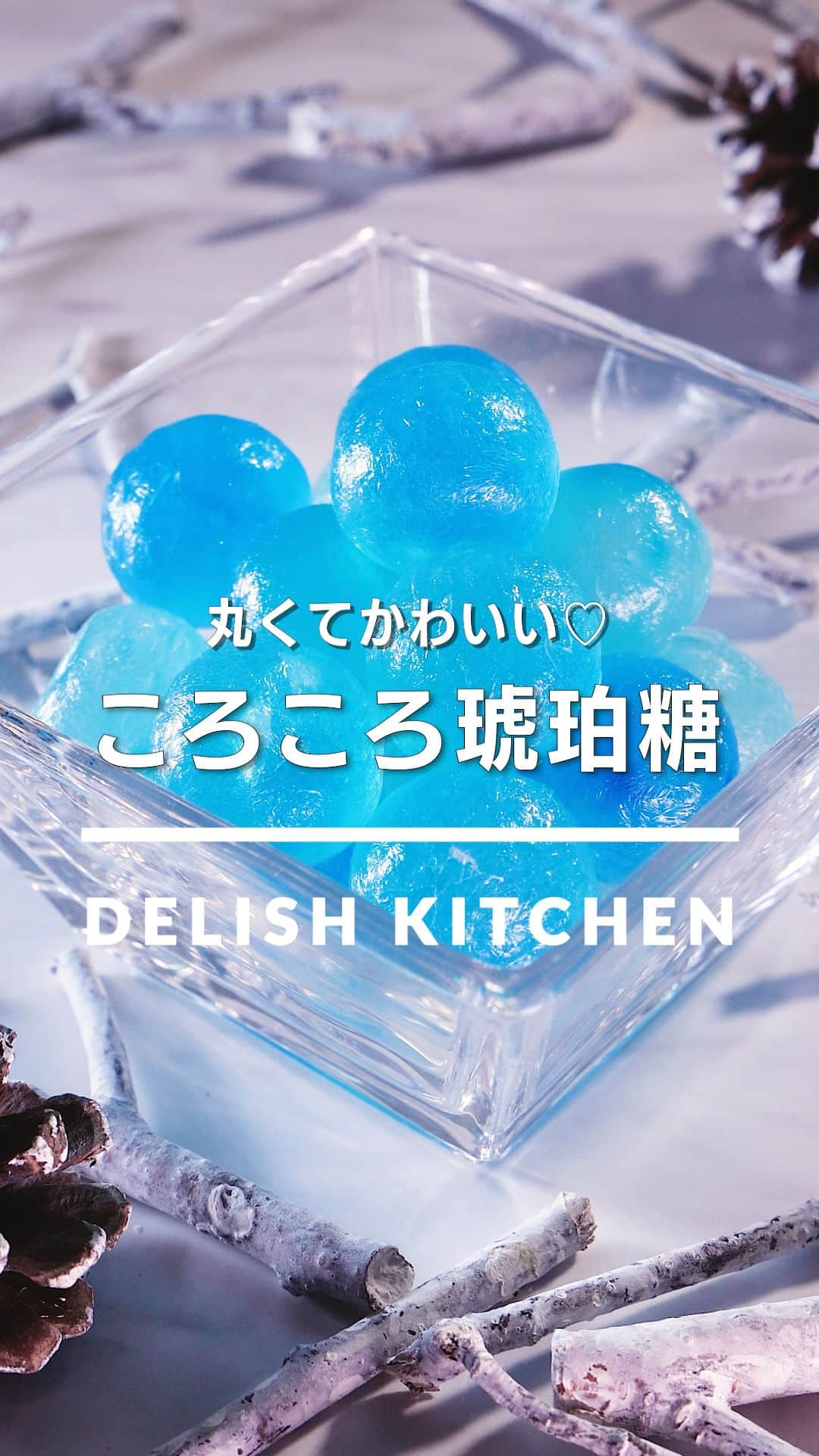 DELISH KITCHENのインスタグラム：「「ころころ琥珀糖」 ⠀⠀ 寒天液をかためて乾燥させて作る琥珀糖。今回は丸い型でかためてころころとかわいく仕上げました♪お好みの色で作ってお楽しみください！ ⠀⠀ ★┈┈┈┈┈┈┈┈┈┈┈┈★ au5Gチャンネルでも、その他様々なDELISH KITCHENの簡単レシピを配信中！ 詳しくは @delishkitchen.tv ハイライトから♪ ★┈┈┈┈┈┈┈┈┈┈┈┈★ ⠀⠀ 動画を一時停止したい場合は、画面を長押ししてください！ ⠀⠀ 動画の詳細が気になる人はアプリで「ころころ琥珀糖」で検索してみてくださいね♪ ⠀⠀ ■材料 (200cc容量の球体ゼリー型2個分) ・グラニュー糖　300g ・水　200cc ・粉寒天　5g ・食用色素[青]　適量 ⠀⠀ ■手順 (1)鍋にグラニュー糖、水、寒天を入れて弱火で加熱し、混ぜながらとろみが出るまで5分ほど煮詰める。 (2)型に5mmほどの高さずつ寒天液を流し入れる。食用色素を少量ずつのせて竹串などでひと混ぜする。残りの寒天液を型の側面の半分の高さになるまで流し入れ、ふたをする。冷蔵庫で30分以上冷やし固める。(お好みの食用色素を使用してください。) (3)型から取り出し、クッキングシートにのせる。風通しの良い場所におき、4〜5日乾燥させる。(冷蔵庫や、ほこりの被らない風通しの良い冷暗所で乾燥させてください。) ⠀⠀ #デリッシュキッチン #DELISHKITCHEN #料理 #レシピ #時短 #おうちごはん #手料理 #簡単レシピ #手作りごはん #今日のごはん #おうちカフェ #琥珀糖 #キラキラ」