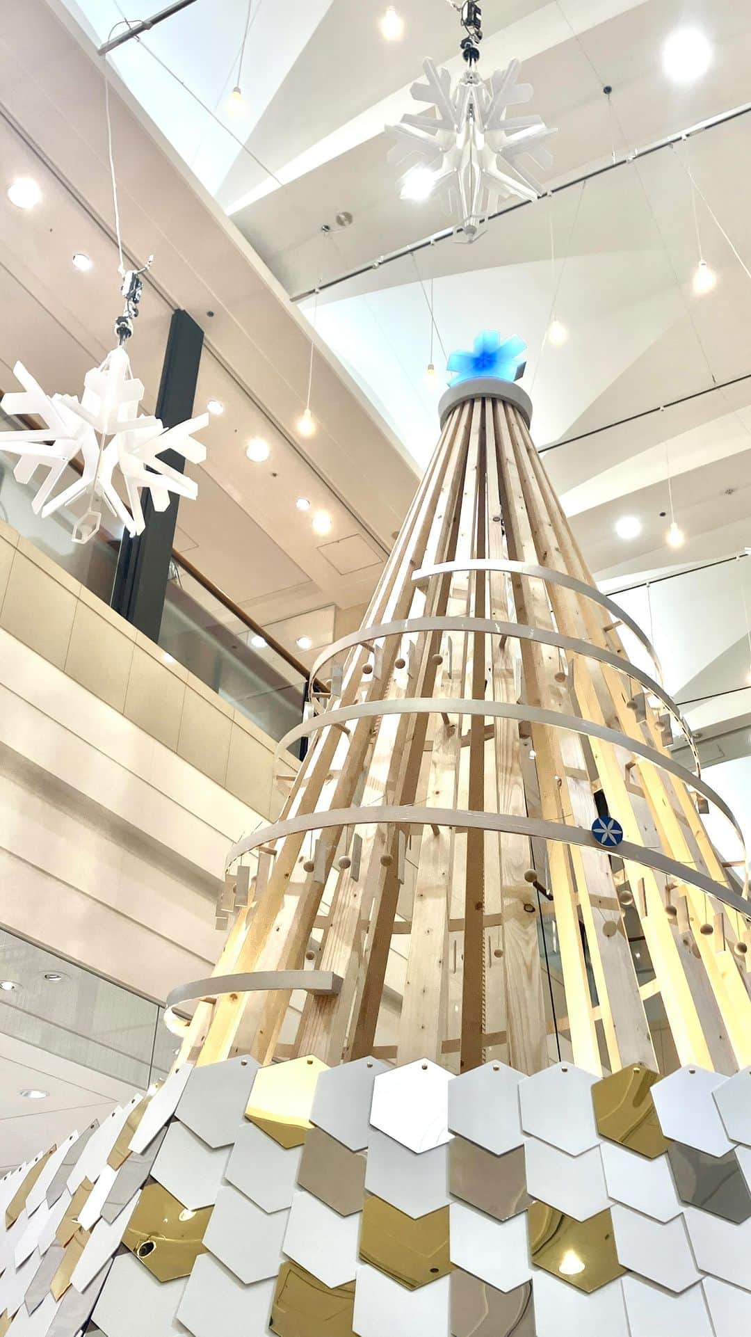 daimarusapporoのインスタグラム：「雪降る街のクリスマスツリー❄️🎄 もうすぐクリスマス💫1階 吹き抜けには、大きなクリスマスツリーが登場しました！  今年のクリスマスツリーには、ある秘密があるんです👀  ツリーをぐるりと囲む木のレールには、何やらチャイムのような仕掛けが。 その上を車が転がると、オルゴールのように音楽が奏でられるんです。  どんなメロディーなのかは、ぜひ実際に聞いてみてくださいね🥳  さらに、ツリーの上に浮かぶのは大きな雪の結晶❄️ 雪の降る都市・札幌ならではのモチーフです⛄️  さらにこの雪の結晶、光りながら動く仕組みになっています！  下から見上げると、キラキラと回る雪がとっても綺麗。 こちらもぜひ実物を眺めてみてください💫  どちらも12/25(月)までご覧いただけます🎄  #大丸札幌 #クリスマス #クリスマスツリー #札幌クリスマス」