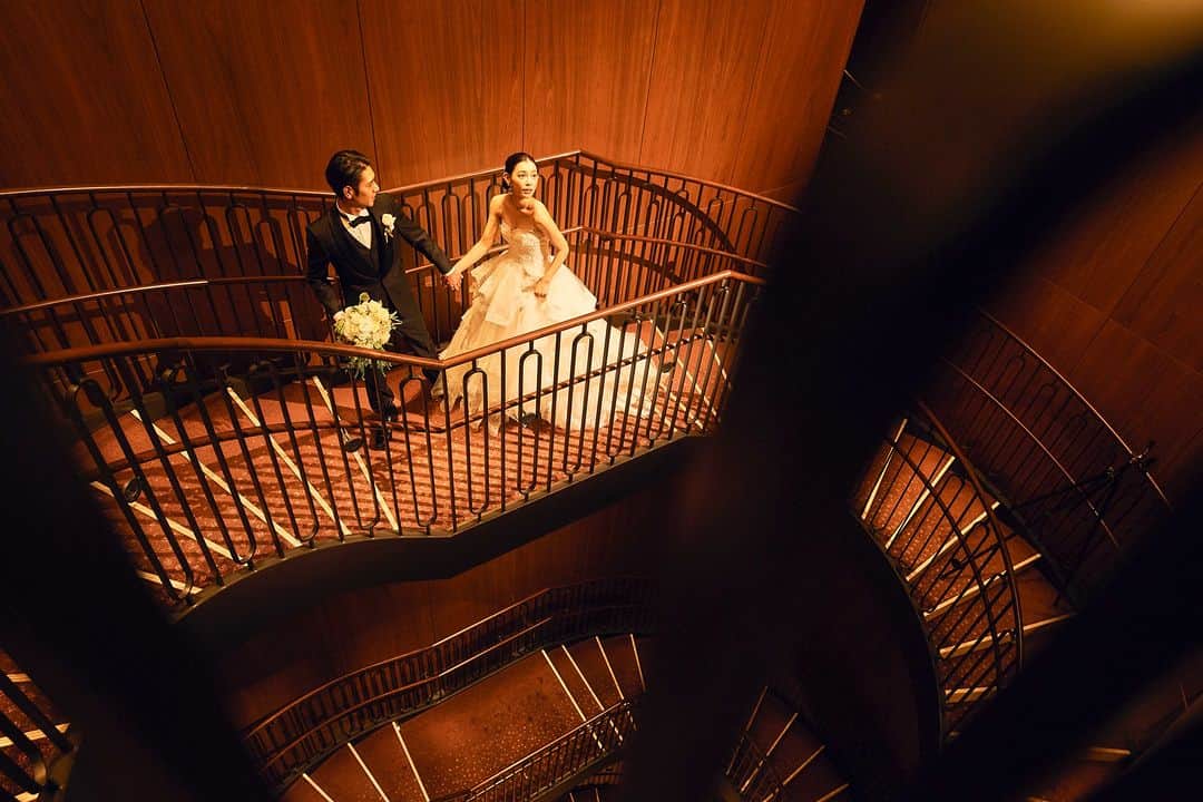 東京會舘本舘ウエディングのインスタグラム：「@tokyokaikan_wedding .——————————. * 重厚感ある螺旋階段での一枚は まるで映画のワンシーンのようなお写真に。  伝統と新たな感性が 見事に融合された特別な空間を 心ゆくまでご堪能ください。 * ——————————. #東京會舘 #tokyo #関東花嫁 #weddingdress #東京花嫁 #wedding #dress #ウェディングドレス #プレ花嫁 #卒花 #結婚式場 #日本中のプレ花嫁さんと繋がりたい #結婚式準備 #ウェディングレポ #ブライダルフェア #チャペル #結婚式 #パーティ #披露宴 #weddingparty #結婚式場探し #大正ロマン #ウェディング #式場探し #式場見学 #日本中の花嫁さんと繋がりたい #花嫁コーデ #結婚式前撮り #ウェディングフォト #令和花嫁」