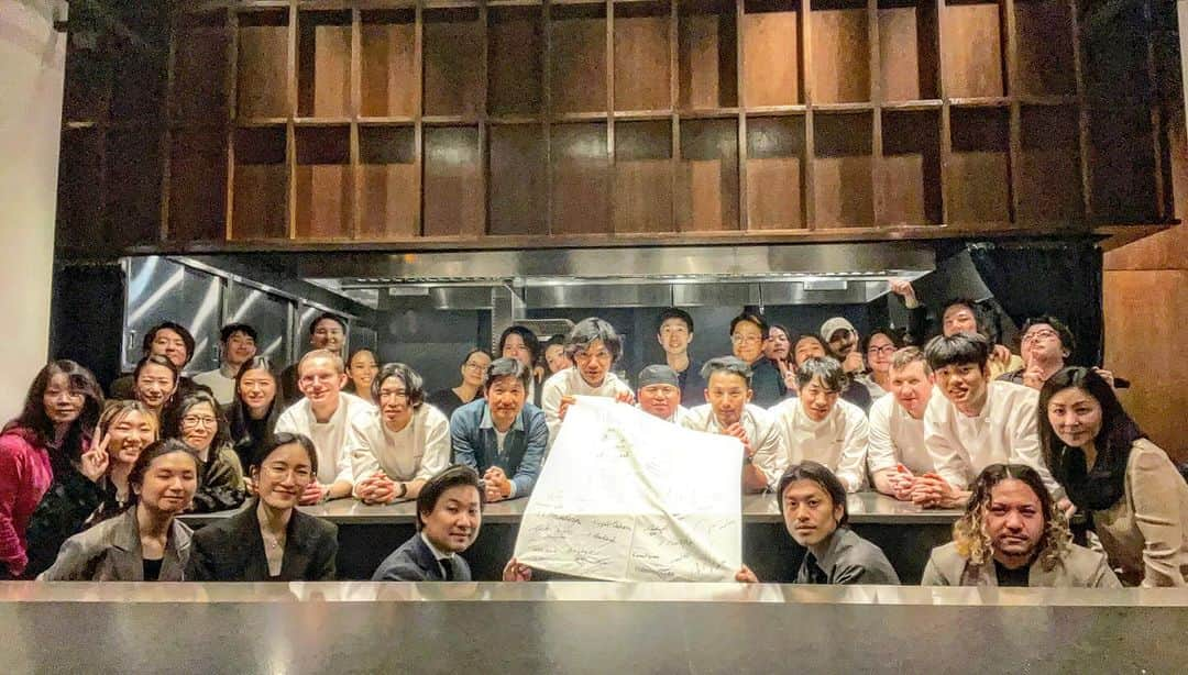 松山智一さんのインスタグラム写真 - (松山智一Instagram)「studio celebration @restaurant_yuunyc  in BK  二つの美術館での個展を届け、この一年一緒に戦ってきたスタジオスタッフつれての祝賀会。3年前に縮小したスタジオも今では社員３０名ほど。アーティストスタジオでは稀有だろうが、以来、複数の企業コンサルタントを交え、社外アドバイザリーも入り、外資系でキャリアを育んだ人事部長をオフィスディレクターとして迎え入れ、組織つくりを徹底した。  世界が視野に入ってくる上で、これからのグローバル情報化時代、芸術家が世界と歴史に挑むには、質、量、コンテキストともに高いスタンダードを維持しないとならない現実を痛感したからだ。限界値は上げ続けないとならない。気を抜けば一瞬で蹴落とされる。   どれだけ疲弊して時間を組織運営に取られても、スタジオの成長を感じる日々に充実感を得た。今回、同時に開催された大きな美術館個展二つを届けられたのことは、今後の大きな自信となるだろう。ここ３年間、製作費の次に注ぎ込んだ自分への投資。未来が見えたかの様だ。  スタッフは仲間ではない。馴れ合いもない、友情もない、血縁もない。ドライでいい、しかし、明確なゴールの共有がある。そうした組織の強さを学べた。   そんな中、昨日、つい先日NY にてミシェランの星を獲得したレストランYUU @restaurant_yuunyc のオーナーシェフ @yuushimano 氏に無理いって借り切らせてもらった。彼もまた違うフィールドでチームで結果をだす戦友。スタジオの皆と、より高いゴール設定をもうけるためにその勇姿と良き時間を堪能。YUUのみなさん、ありがとうございました。」12月6日 4時10分 - tomokazumatsuyama