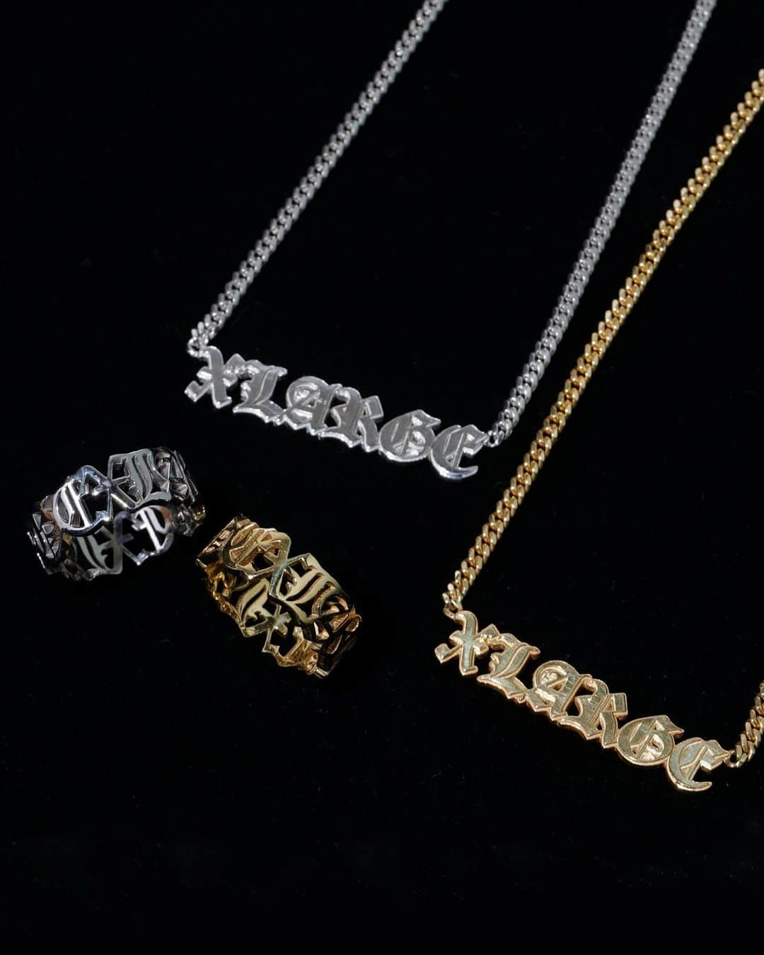 エクストララージのインスタグラム：「12.9.sat XLARGE×GRILLZ JEWELZ  東京の上野 御徒町にある、国内外トップクラスのラッパーたちから絶大な支持を得ているジュエリーショップ「GRILLZ JEWELZ(グリルズ・ジュエルズ)」。 オーナーの秋山哲哉氏は、国内でグリルの文化が殆ど浸透していなかった約20年前から、独学でグリルを作りはじめ、日本初のオーダーメイドグリルショップを立ち上げたパイオニアとして、今や世界中から認知されている。  XLARGEは、第2弾となるGRILLZ JEWELZコラボレーションコレクションを発表する。 カリグラフィ書体として認知度が高く力強い印象のオールドイングリッシュフォントを使用したXLARGEロゴを、秋山氏がジュエリー用の立体につくり起こし、こだわりのディティールとフォルムで表現したネックレスとリング。 ネックレスは、海外のトップアーティスト着用率が最も高く、国内ではなかなか手に入らないマイアミキューバンチェーンを使用し、繊細な技術で作られたリングは3サイズ展開となっている。 今回は新たに、XLARGE×GRILLZ JEWELZコラボレーションのラグジュアリーな世界観をフォトデザインで落とし込んだTシャツがラインナップに登場。 日本国内のXLARGE、XLARGE/X-girl全店舗(※アウトレット店舗除く)と、オンラインストア「calif」「ZOZOTOWN」にて、12月9日(土)12:00より発売開始。  - XLARGE×GRILLZ JEWELZ OLD ENGLISH CHAIN NECKLESS - XLARGE×GRILLZ JEWELZ OLD ENGLISH RING - XLARGE×GRILLZ JEWELZ S/S TEE  詳細は、プロフィールリンクをクリック。 #xlarge #xlargejp #エクストララージ #grillzjewelz #グリルズジュエルズ」