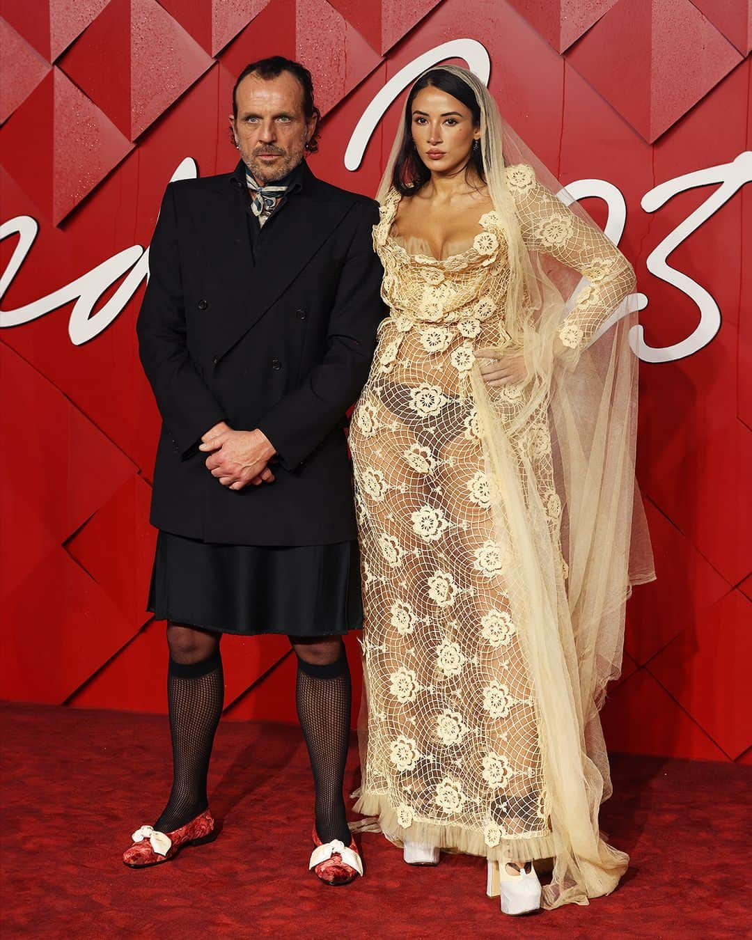 ヴィヴィアンウエストウッドのインスタグラム：「Last night, @ndreasronthaler and @coracorre attended the British Fashion Awards 2023. In honour of Vivienne's work as a designer and activist, a special video of her - speaking as part of a COP26 campaign - was broadcast to guests at London’s Royal Albert Hall. ⁠ ⁠ The footage revealed Vivienne addressing the audience with an urgent call to action. In her own words: “The word economy means household management. Earth is our home, so on a global scale economy means sustainability. We don't have that. We have a financial system based on perpetual war, trade war and competition. It's the cause of climate change. Wars are fought for land and cheap labour. We demand government cooperation. Cooperation not Competition. Save Our Souls”.⁠ ⁠ @letterstotheearth_ ⁠ ⁠  #AKSS24 #FashionAwards #TFA」