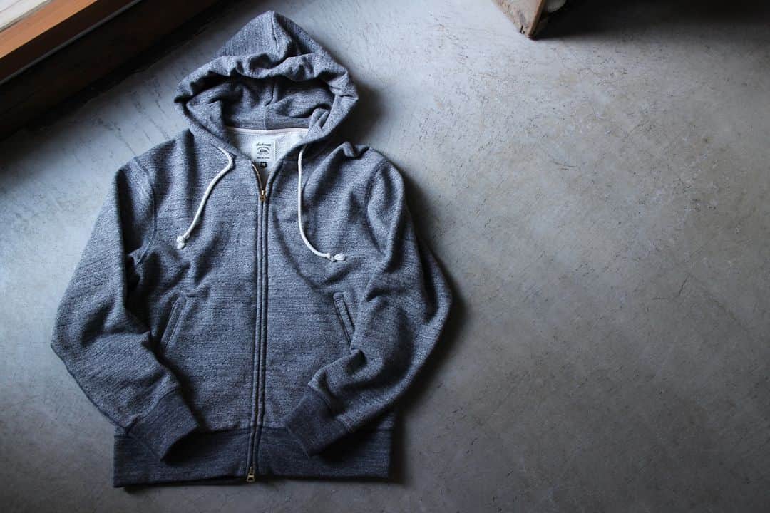 Jackmanのインスタグラム：「▽ FW23 GG SWEAT ZIP PARKA JM7293 100%COTTON ￥19,800 Color:29Charcoal  何度も改良を重ねて完成した 着やすくきれいなフォルムの スウェットジップパーカです  素材は太い番手の国産糸を使用し 日本国内で編み立てた GG(ガラガラ)裏毛を使用  ガラガラの名称は杢糸の濃淡差があり 杢感が際立っていることから ネーミングしたものです  杢糸を使用したカラーは 数色の撚糸を配合し バランスの良い杢感になるように工夫 ソリッドカラーは肉厚感を重視しました  昨年より着心地を良くするために 身巾、肩巾、着丈を修正 また肩周りにゆとりを出すために 肩線にカーブをつけて立体裁断 フードが後ろに倒れないように 首周りの改良を加えました  主要部分の縫製を 縫い代がごろつかない フラットシーマーに変更したことで 肌面の快適性も向上 春まで着用できる スウェットジップパーカです」