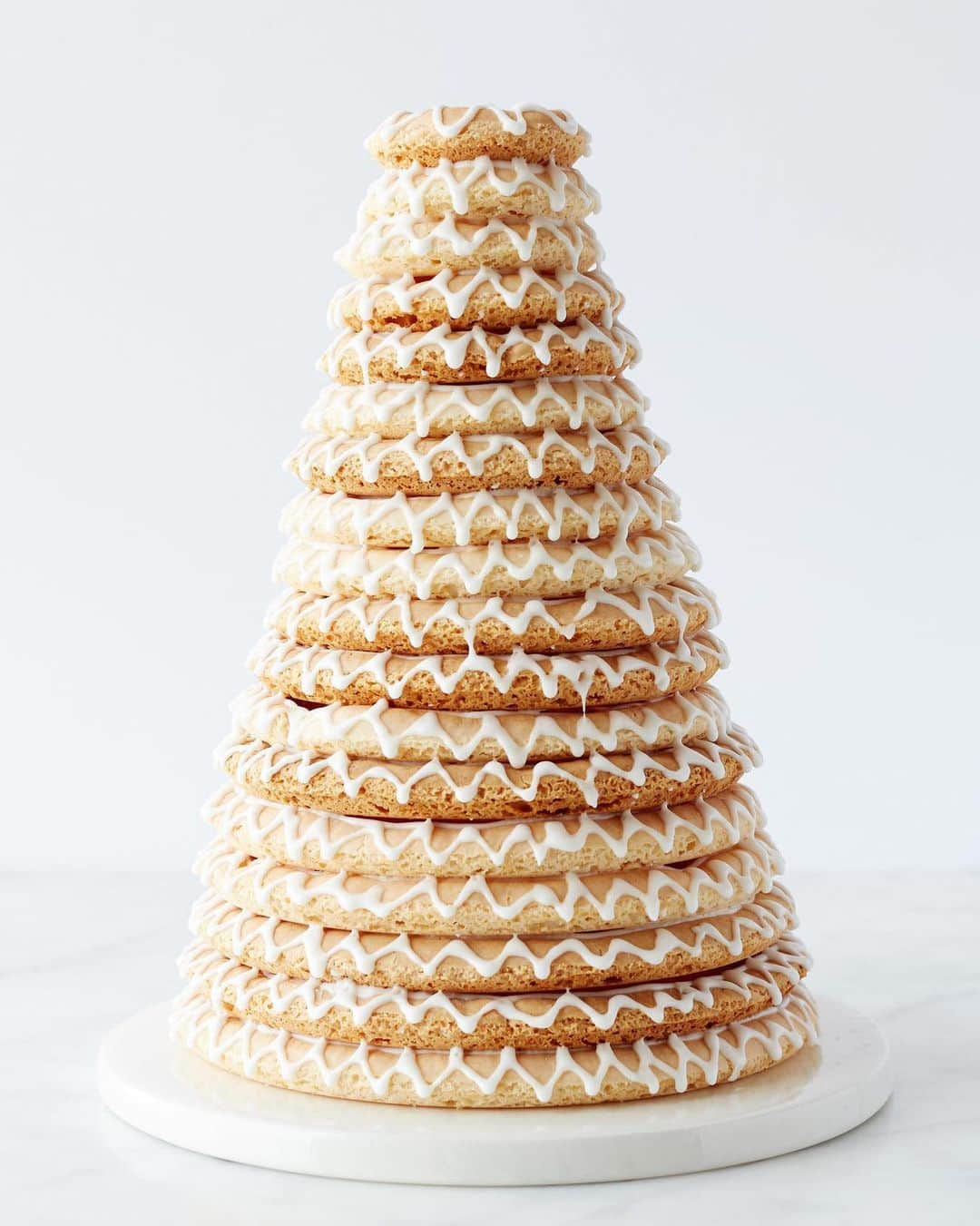 マーサ・スチュワートのインスタグラム：「If you're searching for a stunning way to elevate your next party spread, look no further than kransekake. Translated as "wreath cake" in English, kransekake is a traditional Scandinavian cake made of eighteen almond-based cookie rings with a delightfully chewy texture. What's more, despite its elegant design and towering silhouette, it's surprisingly easy to make. Get the recipe for this beautiful dessert at the link in our bio. 📷: @yossyarefi」