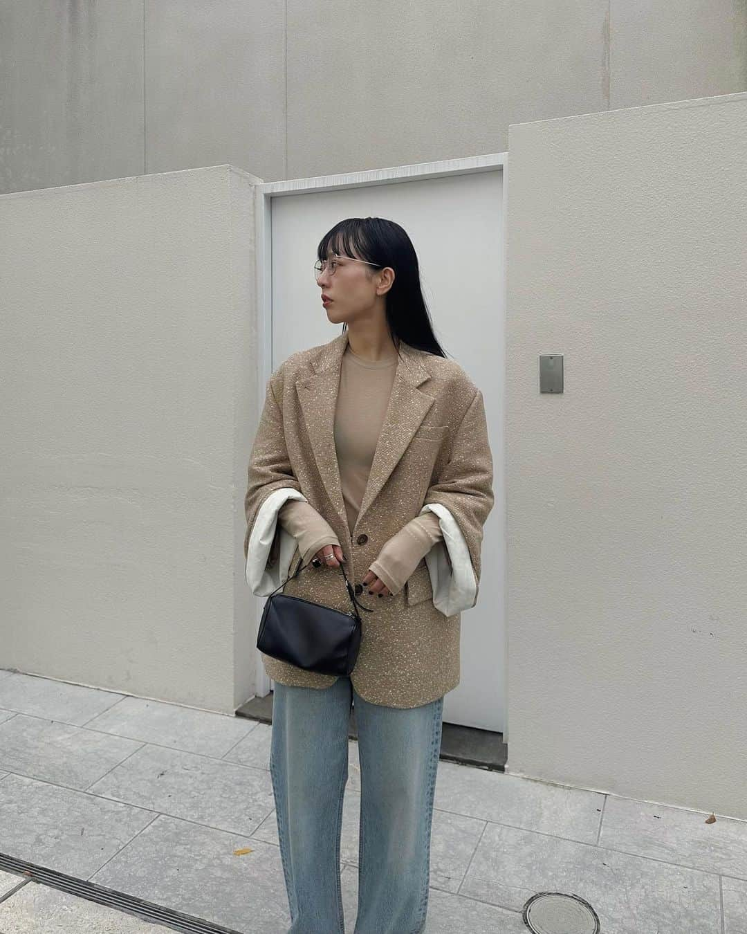 AICOのインスタグラム：「おはようございます。 24SS先行予約会アイテムのご紹介です。  LOOSE BELL SLEEVE JACKET このアイテムは素晴らしい生地との出会いと、素晴らしい機屋さんに作って頂いた思い入れの強いアイテムです。  ベースのベージュ部分はシルクのトップ糸を使用し、白の太番手の糸を横糸に通し斑点状に飛ばす事で全体的に映える柄に仕上げました。 クラシックな印象の素材で大好きです。 程よいコシ感のある素材なのでシルエットもとても綺麗に出ています。  デザインは、ベルスリーブにアレンジしたオーバーサイジングのテーラードジャケット。ベースはシンプルなシングルのテーラードジャケット。袖は前振りを少し付けたベルスリーブデザイン。袖の中にタブと釦を施し止めて頂くとたくったデザインとして袖丈をアレンジして頂けます。更に袖口をロールUPさせ裏側のコットン素材との配色デザインもポイントとして着て頂けます。ラペルには釦ホールを付け閉じて着て頂く事も可能です。シンプルながら一癖と拘りを詰めたテーラードジャケットです。 #clane#24SS先行予約会」