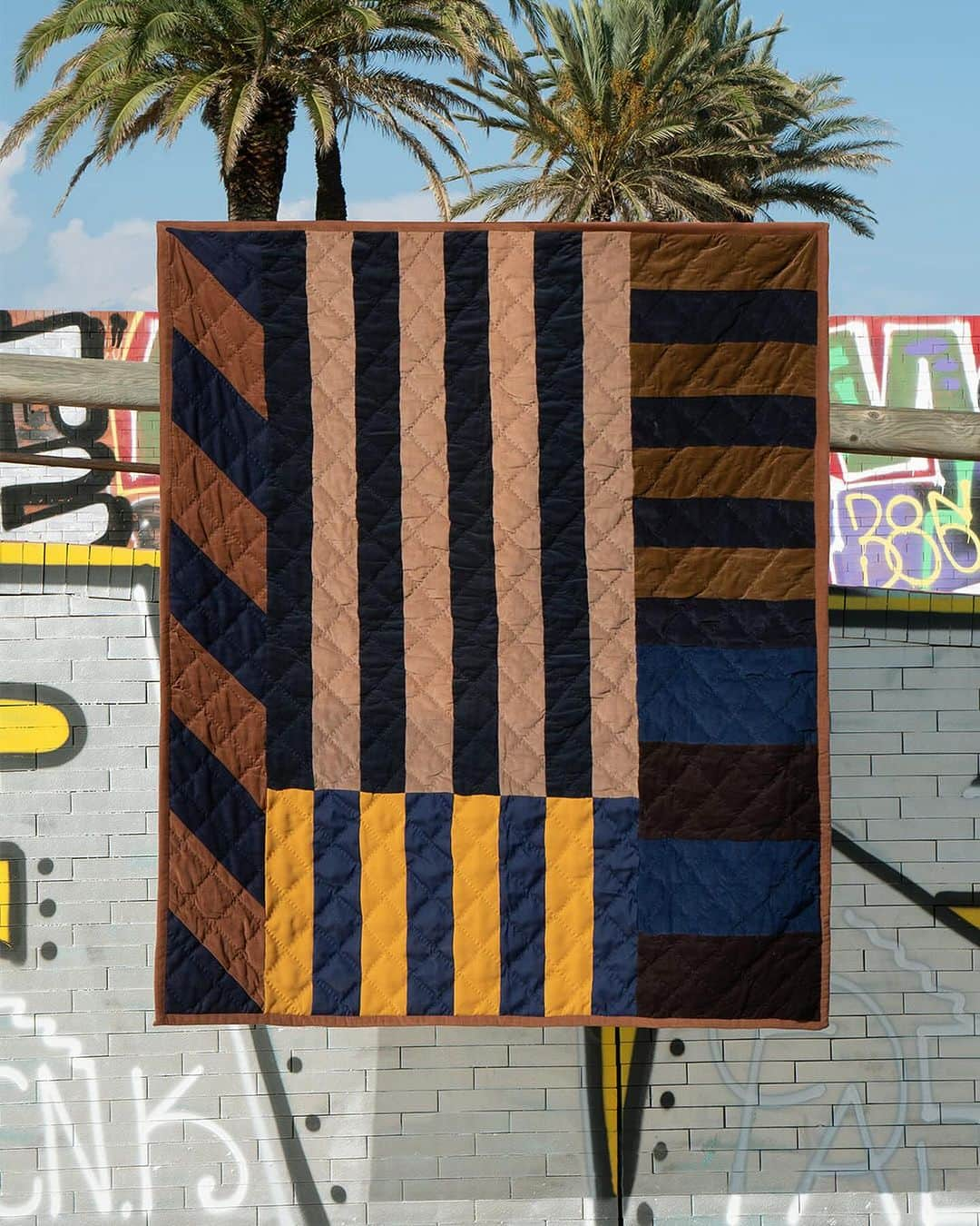 アーペーセーのインスタグラム：「A.P.C. QUILTS ROUND 24   For this drop, Jessica Ogden @the_cats_whiskers drew her inspiration from the paintings of artist Sean Scully.   The rather minimalistic and geometrical design is intentially distrupted by introducing pops of color, reflecting how Scully accents his artworks.   Thoughtfully assembled by hand in India by specialised artisans using leftover A.P.C. fabrics.   Photographed by @alfredo_piola in Barcelona, Spain  #APCParis」