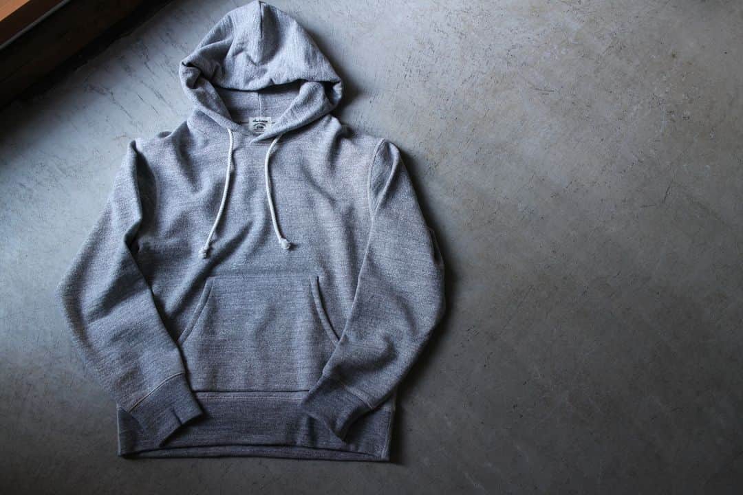 Jackmanのインスタグラム：「▽ FW23 GG SWEAT PULLOVER PARKA JM7295 100%COTTON ￥18,700 Color:30 Heather Gray  ポケットに手を入れた時の雰囲気や 背後から見た時のフードのサイズ感 着用時の愛らしいフォルムといった プルオーバーパーカの持つ魅力を 表現したスウェットです  太番手の国産糸を使用して 日本国内で編み立てることで 肉厚があり1枚で着用しても 重厚感があります  着心地を良くするために身巾と肩巾を拡げ 肩傾斜を付けることで 袖を下げた際の窮屈感を解消  二の腕から袖口にかけてゆとりをもたせ フードも後ろに倒れないように改良を加えました また肌面への快適さを出すため 主要部分をフラットシーマー縫製に変更  着心地が良くなった プルオーバーパーカです 定番のヘザーグレー ぜひ  This sweatshirt captures the appeal of a pullover hoodie: the hands-in-pocket vibe, the size of the hood when seen from behind, and the relaxed shape when worn. The thick fabric is knitted in Japan using  Japan-made yarn, which gives the piece a hefty feel even when worn by itself. This season, we widened body and shoulder widths to improve comfort, sloped the shoulders to eliminate tightness when arms are lowered, added more ease from the arms to the cuffs, and improved the shape of the hood to keep it from falling back. The GG Sweat Pullover Parka has been updated in both appearance and detailing, and now features flat seam stitching in key areas for greater comfort on the skin.」