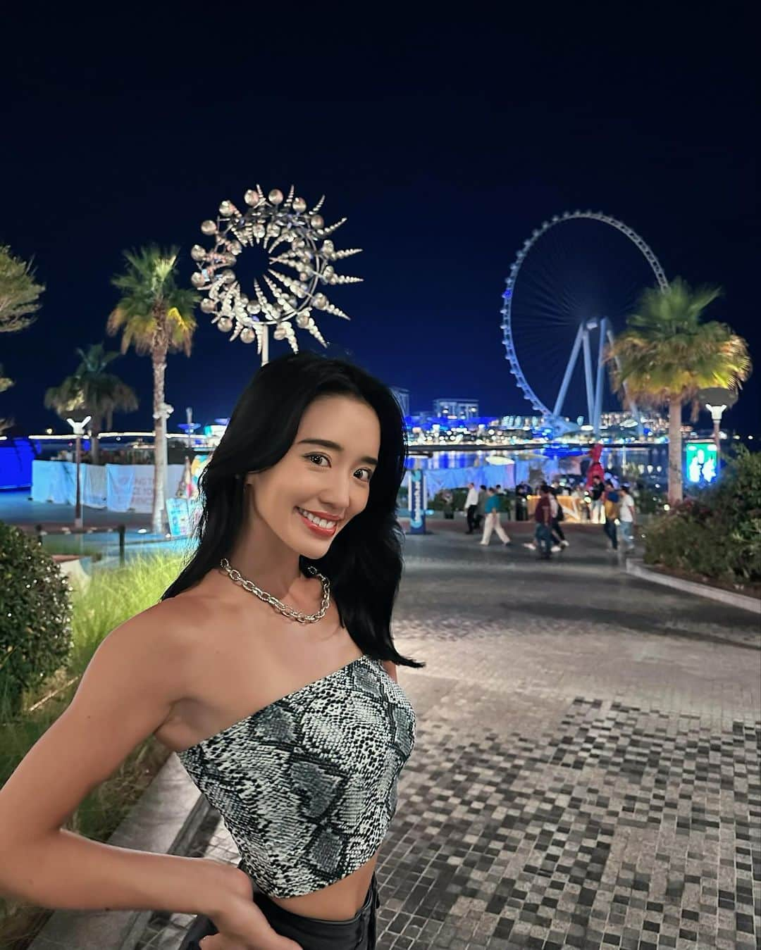 柳本絵美のインスタグラム：「📍JBR Dubai.⛱️ ドバイと言えばのおしゃれスポット👠  ビーチ沿いには有名レストランからおしゃれなカフェまで ずらーっとお店が並んでて、 縁日みたいなコーナーもあったり 夜遅く(3時近く)まで賑やか！🥳治安も良い。 ご飯食べてからシーシャとモクテルでチル🍹 @smokybeachdxb でSushi platterを食べてる 後ろにドローンショーが始まったり👾※2枚目 ノンアルコールだからこんなに居心地良いのかも〜って 最高なナイトアウトでした💫  夏は50度近くになるみたいだけど、 今は夜で22-25度くらいで 涼しくて快適☀️だけどキャミソールは寒いし、 室内は大体冷房で激寒🥶ガチガチ 震えるので、私は必ず薄手の上着を持って行きます🫡 暑い時期以外はパーカーやジャケット (ダウンはさすがに暑いかも)を 1枚ずつは持ってくることをおすすめします🙏🇦🇪  #ドバイ観光  #jbrbeach  #パームジュメイラ #旅スタグラム  #dubaitravel  #dubaimarina」