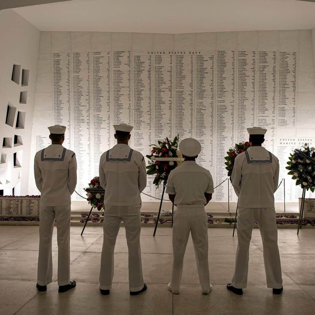 アメリカ内務省のインスタグラム：「Eighty-two years later, we honor the valor and legacy of the 2,403 service members and civilians who were killed during the attack on Pearl Harbor and the brave people whose lives were taken during World War II.    At @pearlharbornps, learn about one of the most pivotal moments in U.S. history and the sacrifices of those who lost their lives during the Pacific War.    Photo by NPS    Alt Text: Four U.S. Navy Sailors stand in front of the USS Arizona Memorial and pay tribute to the names of military members written on the wall.」