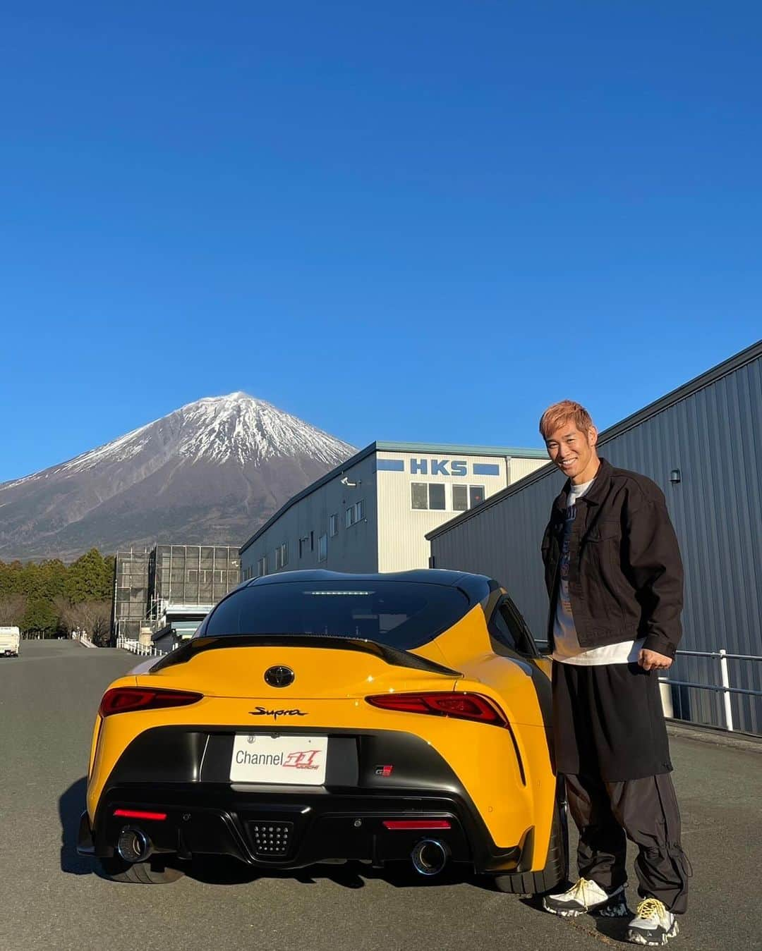 レイザーラモンHGのインスタグラム：「自動車チューニングパーツメーカーのHKSさんの本社にプロレーサーの脇阪寿一さん @juichiwakisaka とお邪魔してきました！創業51年！業界を牽引する超老舗メーカーは世界遺産でもある富士山の麓に広大な敷地を有し、何棟にもおよぶ工場で開発、製造、テストを行っており、その規模にただただ圧倒されました😳  今回、HKSさんのご好意で私HGのGRスープラにあるカスタムをしていただきました！そして製造工場にカメラ初潜入！ この模様は後日、脇阪さんとHGのYouTubeチャンネルで大公開フォー☀️」