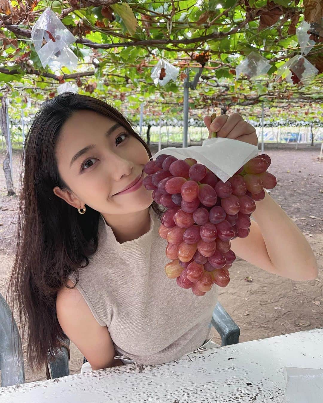 松田和佳のインスタグラム：「🍇  季節外れな寒そうな写真ごめんなさい🥹  10月のぎりぎりノースリーブ着られるくらい暖かかった時にぶどう狩りに行ってきた時の😚📸 カメラロール遡って発見したので投稿しておきます🙆🏼‍♀️💜笑  ぶどうでお腹いっぱいになれるの幸せだったな〜 私が持ってるぶどう、種がなくて甘くてすごく美味しかったのですが、品種忘れてしまいました…なんだっけ🥺  #山梨県 #ぶどう狩り #フルーツ #ぶどう #葡 #勝沼ぶどう郷」