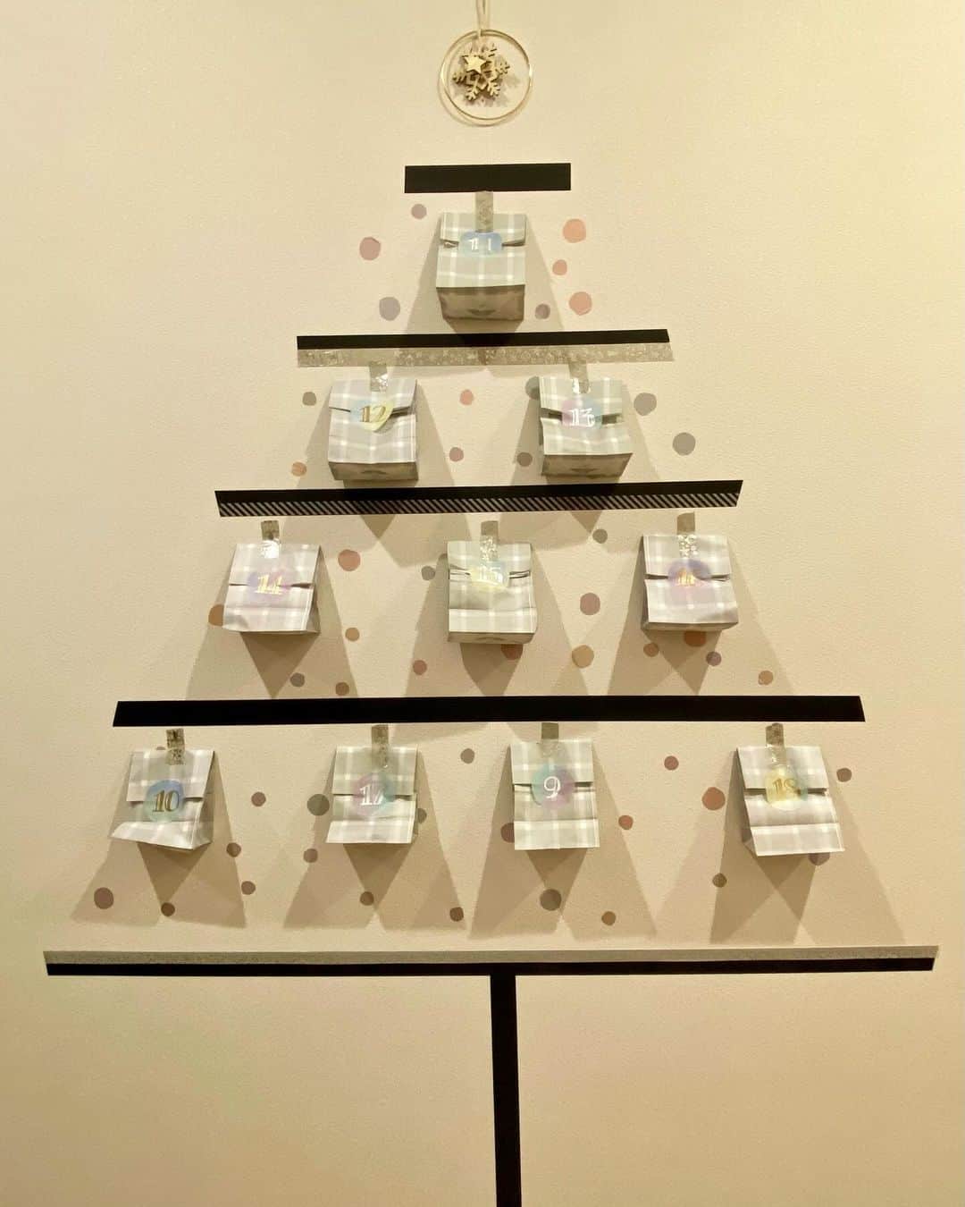 tomekkoのインスタグラム：「【今年のマステツリ〜🎄】  気づけば12月入ってて先週末大慌てで作った今年のマステツリーはこんな感じです。  去年は角を使って立体的にしてみたけど今年はアドベントカレンダーを兼ねたかったので廊下の壁に大きく作りました。  アドベントカレンダー、去年までは小さな引き出しタイプのものに3人分のお菓子を入れなくてはならず、ちっちゃーい飴ちゃんとか探してギュムギュムに詰め込んでたので子どもたちもあまり喜んでくれてなかったんですよね😅  今年は紙袋に軽めのお菓子を入れて、字が書けるフレークシールに日にちを書いてマステツリーに貼る形にしました。  最初に貼ってから5日経ってるけど今の所落ちてきたりはしていません。  ちなみに、毎年やっててコメントでもいただくことがあるんですが、テープ剥がれてきませんか問題。  今回は今の所どこも剥がれてこないので予想だけど、買ってから時間が経っているものや、なんかの付録でついてくるようなものだと剥がれやすいかも？です。  マステツリー始めてはや7…年め？（どうやら2017年が最初らしい）  最初は赤ちゃんがいるから、マンションで狭いから…という理由だったんですが、今では家の中はマステ一択です。  もちろん本物のツリーの方が迫力あるし見ても素敵！となるんだけど、ワタシのような  ・飽きっぽい（毎年違う色やデザインにできる） ・めんどくさがり（出すのもしまうのも億劫→貼るだけ、ビーッと剥がしてポイするだけ）  人にはほんっとうにおすすめです〜！  2年連続で落ち着いた感じになったから来年はビビッドなツリーにしようかな⭐︎  デザインを考える時間も楽しいのであー今年まだツリー出してないやーという方は今からでもぜひ♪  詳しい作り方(というほとでもない)はブログで書いてますのでハイライトからどうぞ。  #マステツリー #クリスマスツリー  #クリスマス準備 #アドベントカレンダー」