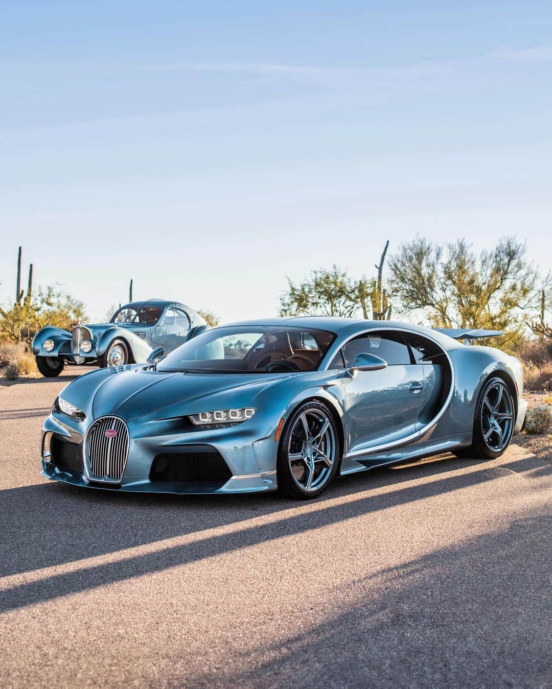 ブガッティのインスタグラム：「We celebrate a rare moment in automotive history: The CHIRON Super Sport ’57 One Of One’, BUGATTI’s most recent ‘Sur Mesure’ project, meets its paragon, the BUGATTI Type 57 SC Atlantic nearby the home of its current owner in the desert of Arizona.  It has been a lifelong dream of the CHIRON’s new owner to pay homage to the Atlantic, which she calls the most beautiful car in the world since she first saw it in the @MullinMuseum in Oxnard, California.   Now she finally achieved her goal with the creation of her CHIRON Super Sport that reinterpreted the iconic model – a birthday gift from her husband. “Everything is so perfect. I especially love how the colours match,” she adds full of admiration.  Co-created with the ‘BUGATTI Sur Mesure’ team, the development of the ‘57 One Of One’ was a labour of passion that stretched over a year.  #BUGATTI #CHIRONSuperSport #BUGATTISurMesure – WLTP: bugatti.link/consumption」