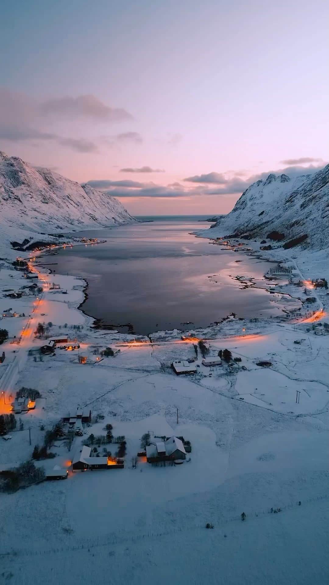 BEAUTIFUL DESTINATIONSのインスタグラム：「Behold the dramatic landscape of Fjord, Norway during twilight, captured from above by @maurocanta_photography. 🇳🇴 After the sun goes down, this wintery haven glows with light leaking from the cozy homes below, creating an incredible view of the stunning horizon beyond. 🏔️✨  📽 @maurocanta_photography 📍 Fjord, Norway 🎶 imperialorchestra - Will and Elizabeth theme | Hans Zimmer」