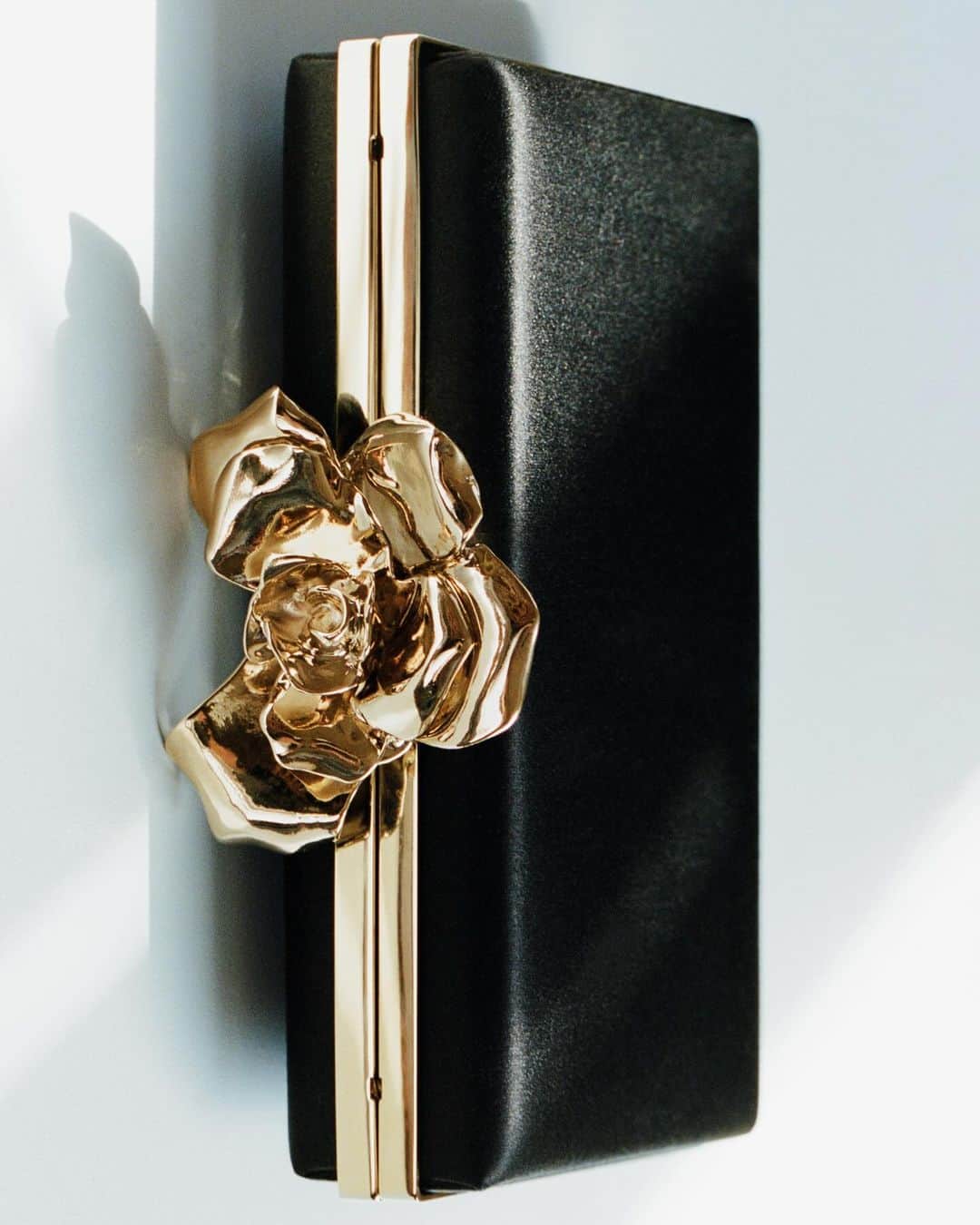 ヴィクトリアベッカムのインスタグラム：「The Frame Flower Minaudiere brings a jewel-like appearance, embellished with a statement flower clasp and fluid satin body.   Available now at VictoriaBeckham.com and at 36 Dover Street.   #VBHoliday」