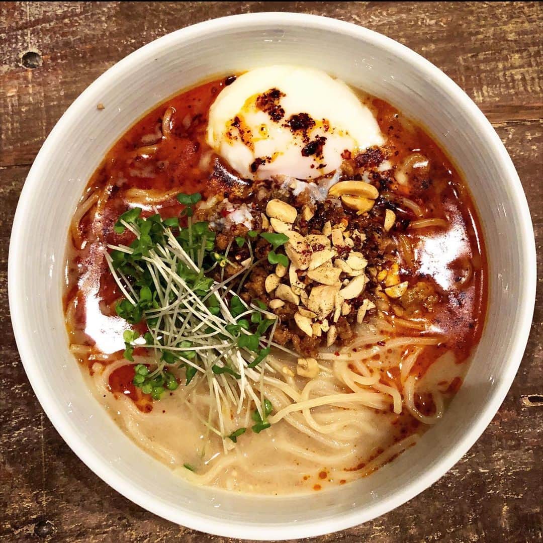 乾雅人のインスタグラム：「GENEI.WAGAN@広尾 今なら会員制のラーメン店の味がテイクアウト・配送で食べられると…あちこちで取り上げられて大人気。 そこに新作「黒酢薫麻辣ナッツ担々麺」が登場とあってはテイクアウトせざるを得ない 笑 麺・胡麻だれスープの素・辣油・香味類とナッツ・温泉玉子・スプラウト…なんちゅうセットや！ さすが「お出汁の神様」の作る坦々麺、出来上がったスープは最後の一滴まで完飲必至。 一口食べるごとに「あ、アレの味だ、あ、コレも入ってる？」とどんどん変化する魔法のような坦々麺。 グルメ予約サイトOMAKASE会員限定なので登録してサイトから申し込むとスムーズ。 #ラーメン #テイクアウト #広尾 #geneiwagan」
