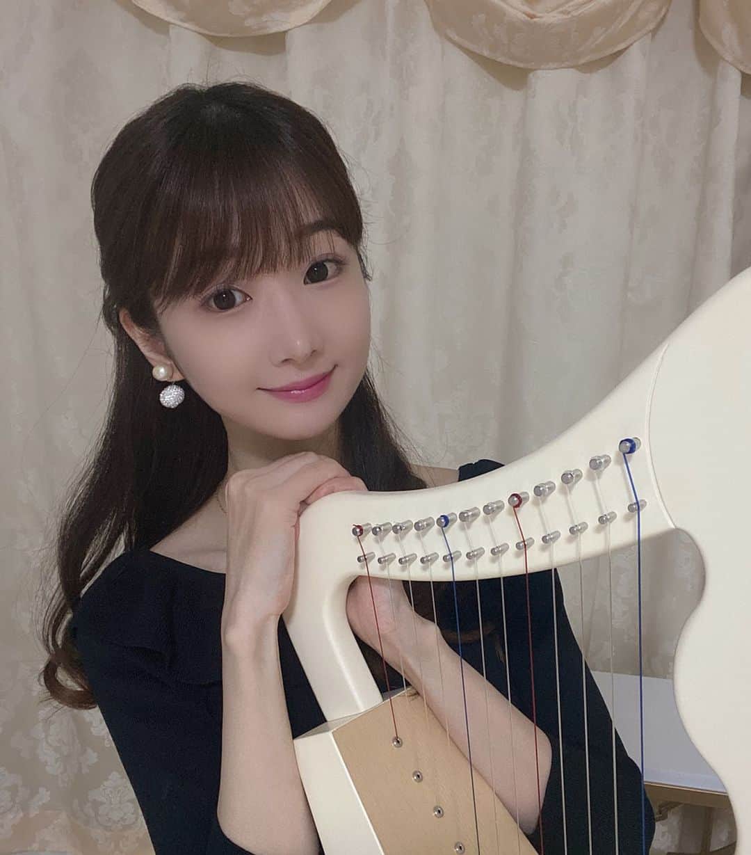 奈々子のインスタグラム：「気付けばあっという間に立夏、今日から蚯蚓出🌱 冬眠していたミミズが出てくる季節になりましたが、奈々子はかれこれおうち時間という名の引きこもり生活を始め1ヶ月以上が経ちました、、、(≧▽≦) 引きこもりすぎて先月から一度もタクシーに乗ってません、、交通費ゼロという素晴らしくエコな月間となっております、、(≧▽≦) . . サロンも先月から引き続き休業しておりますが、オンラインレッスンで生徒さんとお話ししながらレッスンする時間が息抜きになっています(*^_^*) 画面越しでもお顔が見れると安心します♡ . @coco.madonna でお買い物頂くとオンラインレッスンプレゼントもしてますので、是非ご利用下さいね♪ おうち時間の美活アイテムが揃ってます♡ . . 今日は母の日♡ お食事は延期ですが、例年通りお花を贈りました☆ 写真は、自分への誕生日プレゼントのハープと写真撮る為にお化粧しました♪ 安定のセルフタイマーは優秀です☆ . . 皆様のご健康を心よりお祈り申し上げます🌷 . . #立夏 #蚯蚓出 #n75jewelry」
