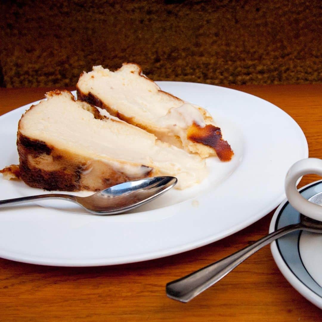 武井義明さんのインスタグラム写真 - (武井義明Instagram)「ベイクトチーズケーキのことを考えていて、そうだ、2016年の年末、ぼくはドノスティア／サンセバスティアンに行き、かの「La Viña」（ラ・ヴィーニャ）で、「tarta de queso」（チーズタルト）を食べているじゃないかと思い出した。いま、ニッポンで流行っている「バスクチーズケーキ」の原型である。バスクに広く知られたバスクチーズケーキというものはない。あるのは、この店の名物タルト。で、そのレシピを調べりゃいいじゃないかと思ったんだが、日本でやってる人は、現地で修業して特別に教えてもらったので、口外できないとＴＶで言ってた。そうなのか？　そんなにケチ？　とおもったら、そんなことはなく、ウェブサイトで、まさしくその「La Viña」の人が、こうつくりますよーと、動画を公開しているじゃないか。どんなチーズを使っているのかだけでも知りたい。きっと特殊なものを使ってるんだ。と、食らいついて見ていたのだが、「queso crema」つまり、クリームチーズだとしか言わない。見た目も別に特別感はないし、なにしろ大量につくっているから、ごくふつうのクリームチーズに思える。ほかもいろいろ調べると「フィラデルフィアのクリームチーズを使っている」と出てきたりする。ふうむ‥‥。しかーし！　動画、さすが！　混ぜ方、混ぜ方！　ぼくはとうぜんのようにフードプロセッサーを使ってとろっとなめらかにしていたんだけど、クリームチーズ▶卵▶砂糖▶薄力粉▶生クリームを、大きいスプーンで、かなりざっくり混ぜるだけなのだった。完全にチーズが溶け切っていない！　そして、表面にカラメルなんてのってない。それは日本オリジナルらしいな。そして一所懸命「La Viña」の味を思い出そうと写真を見返したんだけど、おいしいことはおいしかったけど、べつに「超すげー！」ということはなく、ふつうにおいしいチーズケーキだったように思う。旅情が味を濃くするのだ。わざわざここでという達成感もあるし、立ち食いの楽しさもあって「おいしい」わけなのだ。でも、しつこいようだけど、日本のチーズケーキはすごいですよ。ほんと。」5月11日 12時53分 - bebechef
