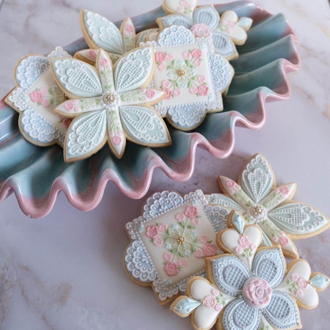 KUNIKAのインスタグラム：「Baby rose and lace pattern design cookies for mermaids 🧜‍♀️﻿ ﻿ @iroha.vintage さんで一目惚れしたシェルのプレートに載せたら、人魚姫のためのクッキーになりました🐚﻿ 色味が絶妙なマーブルで、ほんとうにかわいい...﻿ いつかこのお皿にぴったりな人魚モチーフのクッキー作ろう🧜‍♀️﻿ ﻿ ﻿ ﻿ ﻿ #artofkunika #kunicookie #sugarcookies #decoratedcookies #cookieart #decoratedsugarcookies #royalicing #royalicingcookies #cookiedecorating #customcookies #cookiesofinstagram #cookiedesign #cookieartist #instacookie #azulejos #azulejo #azulejoportugues #tiledesign #tileart #tiles #mermaid #rose #lace #shellplate #糖霜餅乾 #糖霜曲奇 #아이싱쿠키 #아이싱 #アイシングクッキー　﻿」