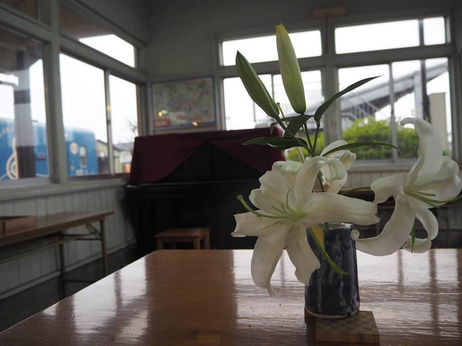 伊藤桃さんのインスタグラム写真 - (伊藤桃Instagram)「【#くま川鉄道 #湯前駅】 16:49おかどめ幸福駅発の列車にのって·····次に向かったのは終点、湯前駅✨ うまれはなんと大正12年。 くま川鉄道最古の#木造駅舎です(❁´ω`❁) 3枚目: 現在は有人駅との事でしたが、窓口には誰もおらず····· それもそのはず、なんと6:00~10:00という短い朝の時間にしか駅員さんはいないそう。 小さい窓口がレトロでかわいい😊 4枚目: そおっと駅員室の中を覗いたら、綺麗な生け花とピアノが^^* 🚉 5枚目: ホームには二つの鐘が····· この湯前駅の近くには、縁結びと夫婦円満のご利益がある賽神社と、 子宝そして安産のご利益がある潮神社があり、 それにあやかって、同じご利益がある賽の鐘と潮の鐘があるのです🥰 絵馬をかけるところもありました✨ おかどめ幸福駅につづき、ご利益たっぷりな路線なのですね(●︎´▽︎`●︎) 🚉 6枚目: あまりにものどかで幸せな空間を伝えたくて、思わず動画♡ 山々にかかる淡く白い霞が幻想的で空気が美味しくて·····✨ ゆっくりと時間がながれていました。 車止めのむこうにみえる半楕円？のオブジェが謎だったのだけどだれかご存知ですか？笑 🚉 せっかくなので駅の外へも····· 7枚目: 桜舞う#車止め (*^^*) 8枚目: 併設する形で、地産のものが売られたり、伝統工芸を学べる湯〜とぴあという施設もあるのですが、 この時間はしまっていましたm(_ _)m 今度はいってみたいなあ♡ 9枚目: 雨の中、桜もふりつづけていました🌸//☂﻿// 10枚目: そして列車は折り返してふたたび、人吉温泉駅へ·····´`* ━━━━━━━━━━━━━━━ くま川鉄道の旅もあと少し。 よかったらぜひ最後までお付き合いください♡ また、この後質問コーナーを、 明日の21時から最近の鉄道ニュースできになったものを語るインスタライブをしようかと♡ 17日のオンラインチェキ会とあわせて宜しくお願いいたします！(*^^*)」5月12日 21時24分 - itomomo_tetsu