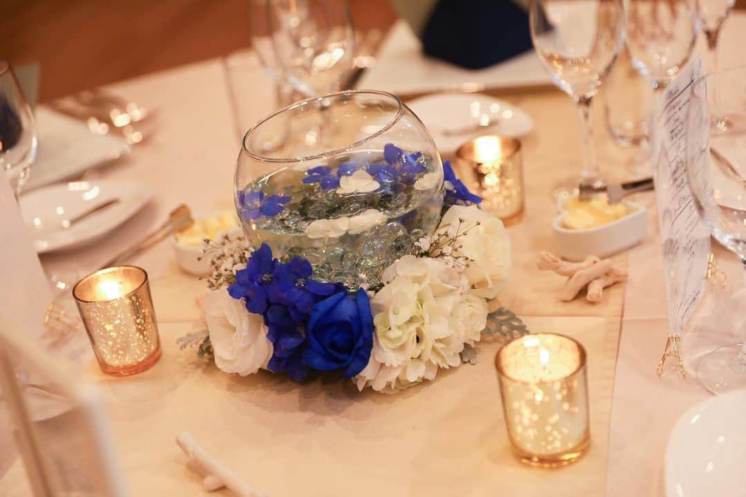 のインスタグラム：「テーブルコーディネート . . キャンドルやクロスをゴールドでまとめブルーのお花がアクセント . . お花だけでなくキャンドルなどの小物を飾ることでより華やかな印象に⭐️ . . オンライン相談会も是非ご参加ください！ ・ https://lumiamore.com/ information_l@lumiamore.com ⠀ ・ ・ 5月31日迄の臨時休業期間中は最小人数で対応しておりますため、お電話が繋がりにくい場合がございます。着信履歴より確認ができましたら折返しのご連絡をさせていただきますが、改めてのご連絡、もしくはメールにてお問合せをいただけますと幸いでございます。 大変ご不便をおかけいたしますが、何卒ご理解賜りますようお願い申し上げます。 ・ ・。・。・。・。・。・。・。・。・。. . 『#lumiamore』のハッシュタグをつけて お写真を投稿してくださいね♪♪. こちらの公式IGで取り上げさせていただきます＊ .  #ルミアモーレ #wedding #instawedding #結婚式 #ウェディング #結婚式場 #f4f #l4l #instagood #プレ花嫁 #結婚式準備 #花嫁準備 #日本中のプレ花嫁さんと繋がりたい #おうち時間 #stayhome #オンライン相談 #オンライン結婚相談 #ブライダルフェア」