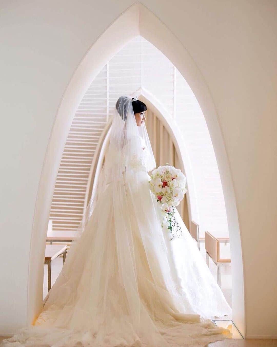 25ans Wedding 公式 Bridesのインスタグラム：「今日も、まなさんのポストから💫「パレスホテル東京」のチャペルは、白を基調としたモダンなデザインで花嫁たちを魅了してきました⛪️ チャペル横の出口も洗練された佇まいで、美しいドレス姿を残すのにぴったりなスポット。」