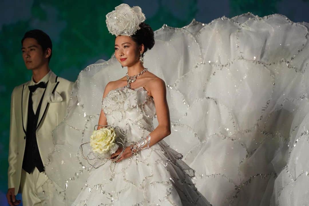 yumikatsuraのインスタグラム：「*﻿﻿﻿﻿ Yumi Katskra Brilliant White Debut﻿﻿ 純粋、清純、神聖、希望、心機一転など白色が持つ様々なイメージを、誕生から始まり七五三、成人式、起業式、そして人生のハイライトともいうべき結婚式を—そしてその後に続くウエディングアニバーサリーとして15年目、30年目、55年目の大切な節目、節目の装いを、すべて色々をモチーフをデザインし披露。﻿﻿ ﻿﻿ 結婚式(畠山愛理 @airihatakeyama ):﻿ ローズユミをイメージし、300枚の花びらで飾られたドレスは、晴れの日に大輪の花として咲き誇ります。﻿﻿ ﻿ 本日放送！お見逃しなく💐﻿ ﻿ ﻿﻿桂由美密着ドキュメンタリーが放映されます✨﻿ ■番組名 NHK ＢＳ１スペシャル「桂由美　幸せを呼ぶ“純白”のドレス」 ■放送日時／５月１６日（土）１６時より　BS  ４K﻿ ５月１６日（土）２１時より　BS1  2K﻿ ﻿ 「ブライダル」――55年前、日本に初めてこの言葉を普及させ、当時和装中心だった婚礼衣装に、女性たちの憧れであったウェディングドレスを浸透させていった桂由美。ブライダル人生一筋、創作活動55年記念イベントとなる国内88回目のグランドコレクション開催までの日常を半年間にわたり追い続けた初のドキュメンタリー番組。今もなお、「まだ道半ば」と語る桂由美の思いとは何なのか・・・また、桂を支えるユミカツラクリエイティブチーム面々のインタビューシーンや初のアトリエ公開シーンなど、乞うご期待です。﻿﻿ ﻿﻿ ﻿﻿ ————————-﻿﻿ ﻿#stayhome #おうち時間 #おうち時間を楽しもう #おうちじかん #プレ花嫁準備 #プレ花嫁2020 #プレ花嫁diy #プレ花嫁応援 ﻿#yumikatsura #ユミカツラ #桂由美﻿﻿ #ウェディングドレス #ユミブライズ﻿﻿﻿ #YumiBrides﻿#wedding #happywedding﻿﻿ #ウェディングニュース﻿﻿ #プレ花嫁 #全国のプレ花嫁さんと繋がりたい﻿﻿」