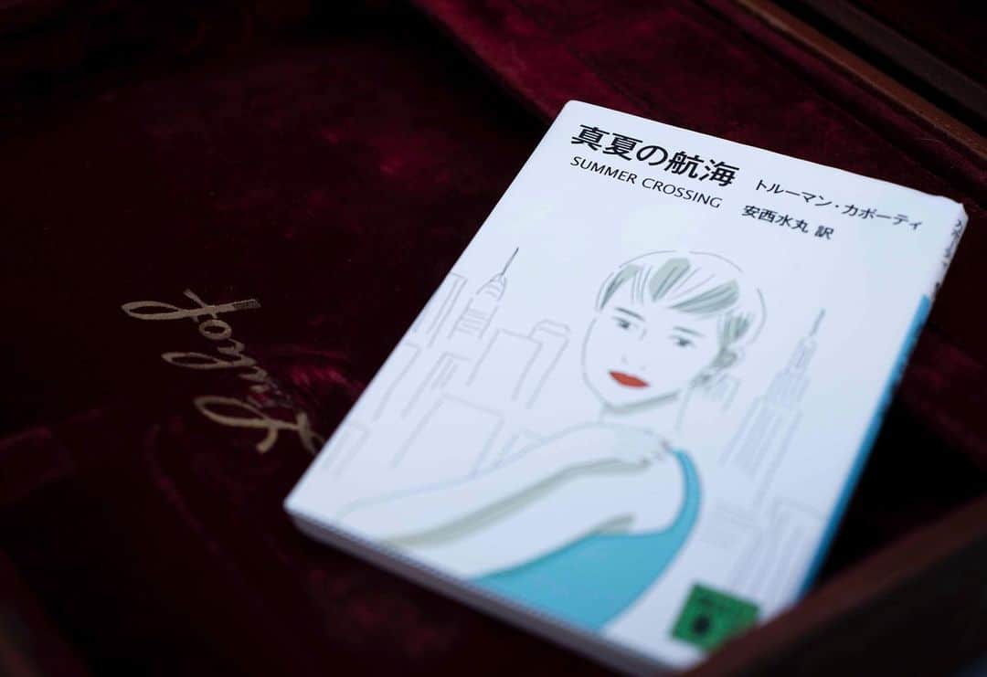 のインスタグラム：「文庫ブックカバーチャレンジ 本日は『真夏の航海』（トールマン・カポーティ/著　安西水丸/訳　講談社文庫）  ジンクス　4 　改めて、店内を見回してみる。少しだけれど、自分の中に余裕が感じられたからだ。漆喰の壁が居心地を良くさせる舞台装置のようにも感じられる。カウンターには七人の男女が座り、満席だ。ぼくを含めた七人は語り合う訳でもなく、無言のままカウンターに向かっている。それぞれの前にはなぜか原稿用紙があり——中には大学ノートの人もいた——、右手には鉛筆やシャープペンシル、万年筆、水性サインペンとそれぞれのスタイルのペンを持っている。 　左手にはグラスを持っていたり、タバコを差していたりしている。酒はそれぞれの前にはあるけれど、それでも酒として機能はしていないように見えた。酒はペンで、肴が原稿用紙とでもいったら良いのだろうか。料理に合わせて、ソムリエがワインをリコメンドするかのように、組み合わせは良く、繊細なハーモニーを奏でているようだ。しかし、それはあまりにも奇妙で不自然な、もしくはマニアックなバーのカウンターの景色であるはずなのに、カボシャールという空間では、それは自然なことだと瞬きをする間にわかることなんだと思うしかなかった。ここはそういう場所なのだ、と自分にいい聞かせるしかない。 　黒岩と名告った女性はカウンターの中で不器用に氷を割る。アイスピックはいつ黒岩の左手をぶち刺してもおかしくない角度と長さであった。彼女は小指の付け根を当てながら砕くスタイルではなく、あくまでも自由にアイスピックを氷に差し込んでいく。そして、割れた氷をデュラレックスのグラスに入れていく。ぼくの手元にはすでにコースターが置かれていた。そこには“ジンクス”と印刷されていた。それを不思議に思い、黒岩に目を向けると、彼女はズブロッカをグラスに注ぎ、ぼくに手渡す。小さな声しか出なかったけれど、「ありがとう」といった。そして、「いただきます」といって、グラスを口に運ぶ。ひと口飲み込むと喉から胃にかけて、何かが燃えるように熱くなった。そして、天を仰いで唾するように、噎せた。」