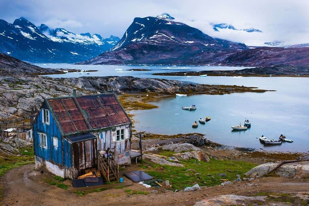 National Geographic Travelさんのインスタグラム写真 - (National Geographic TravelInstagram)「Photo by @MartinEdstrom | Human existence | About 100 people live here in Tiilerilaaq in eastern Greenland. After getting through the belt of ice in the spring, houses are just beginning to thaw and reveal their seasoned faces. Compared to western Greenland, which houses a lot of people, this side of Greenland is almost completely wild. During the few summer months, people will be out and about running errands underneath the seemingly everlasting midnight sun.  Follow @MartinEdstrom for more images of Greenland and the Nordics. #greenland #eastgreenland #ilovegreenland #greenlandpioneer #lastwildplaces」5月19日 9時04分 - natgeotravel