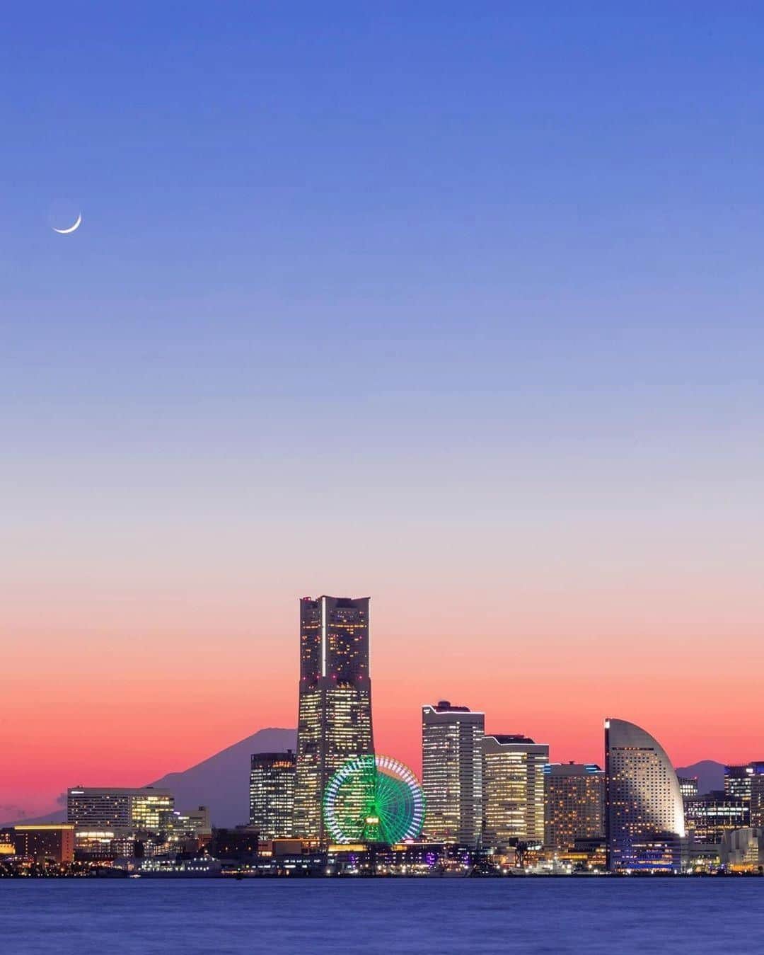 のインスタグラム：「Showcasing #yokohamatomorrow, a collection of memories while looking forward to tomorrow.﻿ ﻿ “Yokohama Minatomirai twilight magic landscape 💫﻿ 過去picストック現像。﻿ 横浜みなとみらいのマジックアワー夜景。﻿ 月が🌙いい感じに出ていて見ていても綺麗でした☺️﻿ 去年の誕生日🎂に会社早退していそいそと現地に赴き﻿ 撮影後は食事もそこそこに現像に勤しんでた記憶が。。。😂😂 平和になりまたこの賑やかしさが戻るのを願って😊﻿ Location Kanagawa Yokohama﻿ Date: Mar 2019”﻿ ﻿ Photo & Text: @dvd.ring﻿ ﻿ #yokohamatomorrow﻿ ﻿ -﻿ ﻿ 皆様がいままでに撮られた大好きな横浜の写真（去年の同じ季節に撮られた写真など）に思い出などのエピソードとハッシュタグ #yokohamatomorrow を付けて投稿していただけないでしょうか？﻿ ﻿ ハッシュタグをつけて投稿していただいた写真を、健やかな日々が戻ってくると信じてご紹介していきます。﻿ ﻿ Looking forward to tomorrow, we have a request: Post your favorite memories and experiences in Yokohama - Something from last year or your last trip perhaps? - with the hashtag #yokohamatomorrow.﻿ ﻿ We will showcase these memories on our Instagram as they represent the Yokohama we are looking forward to while we navigate this challenging time together.﻿ ﻿ #myyokohama﻿ ﻿ #yokohama #darlingescapes #beautifuldestinations #artofvisuals #somewheremagazine #discoverglobe #travelawesome #passionpassport #lovejapan #explorejapan #japanlife #japanfocus #japan_vacations #japanrevealed #よこはま #ヨコハマ #横浜 #stayhome #staysafe #besafe #stayhomestaysafe #staysafeeveryone」