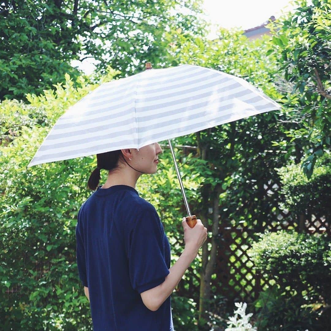 北欧、暮らしの道具店さんのインスタグラム写真 - (北欧、暮らしの道具店Instagram)「【スタッフの愛用品】ボーダー柄の「あの傘」を、当店が毎年お届けしている理由 . - - - - - - - - - - - - 初夏のこの時期にお届けするのが5年目となる、 アンキャシェットの日傘。  お客さまのなかでも、この日傘を見つけると 「今年もそんな季節なのね」と思う方も いらっしゃるのではないでしょうか？  改めてこの日傘の魅力って どこにあるんだろうと気になり、 今回、“ 愛用歴4年のスタッフ竹内” に リアルな声を聞いてみました！ . - - - - - - - - - - - - ■ バイヤー竹内 . 「ワンピースにサンダル。 この身軽さが夏の良さでもありますが、 ちょっとシンプルすぎ？と物足りなくなることも。  家を出てから後悔するときがあるけれど、 玄関でこの日傘を持った姿を見たら、 『なんだかサマになってる』と 自信が持てる気がするんです。  そして、以前コラムで熱く語ったこともあるのですが、 細部に天然素材の良さが光っているんです。 ひとつひとつ雰囲気が異なる持ち手と 留め具は竹でいます。  ネットショップなので選ぶことが出来ないけれど、 家に届いた日にご対面したとき、 『この子はこんな特徴があるのね～』と 妙に愛着が湧いてきました」 . - - - - - - - - - - - - 長傘タイプの日傘を使うスタッフも多いのですが、 子どもがいると荷物が増えてしまうので、中には、 「折りたたみタイプ」に変えたい！というスタッフも。 . 折りたたみも長傘タイプとさほど変わらない大きさになり、 しっかりと日差しから守ってくれましたよ。  UVカット率は90％。 晴雨兼用なので、急な雨からも守ってくれます。  暑さの厳しい日や、雲行きが怪しい日。 この夏もいろいろあるだろうけれど、 自分に合った方法を選んで健やかな毎日を送りたい。  マイベスト日差し対策で迷っている方に、 この日傘を手に取っていただけたら嬉しいです。 . - - - - - - - - - - - - Encachette/アンキャシェット/日傘（長傘・折りたたみ） . ▶︎お買いものはプロフィールのリンクからどうぞ→@hokuoh_kurashi . #fashion#coordinate#Encachette#日傘#アンキャシェット#紫外線#春#夏#折りたたみ#長傘#傘#ファッション#コーデ#コーディネート#シンプルコーデ#シンプル#シンプルライフ#シンプルデザイン#暮らしを楽しむ#日々の暮らし#北欧#暮らし#北欧暮らしの道具店」5月22日 10時38分 - hokuoh_kurashi