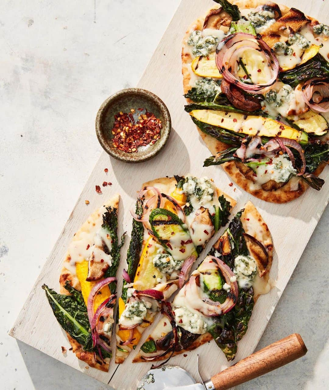 マーサ・スチュワートさんのインスタグラム写真 - (マーサ・スチュワートInstagram)「These easy pies are full of surprises. Grill a bushel of produce—mushrooms, zucchini, red onion, and kale—and pile them onto rounds of store-bought flatbread. Sprinkle on blue cheese and mozzarella to bring a mix of funk and gooeyness. Then, since we've already bucked tradition, skip the marinara and drizzle your pizzas with a simple mustard vinaigrette instead. It offsets the rich cheeses and unites the vegetables into bites so satisfying, no one will notice you're having salad for dinner. Check out the recipe featured in our June issue out on newsstands or available online at @magazinedotstore + Apple News+. You can also visit the link in bio to learn more. 👆🏼 📷: @christophertestani | recipe + food styling by: @sarahcarey1 @brooklyncooks @lucullanfoods | prop styling by: @tanyagraff1」5月23日 8時10分 - marthastewart