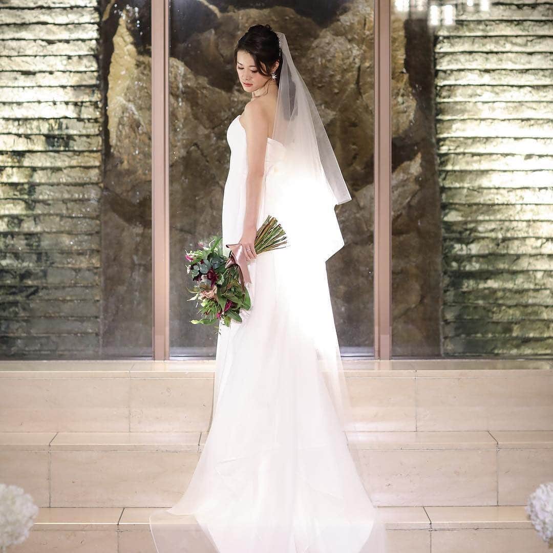 25ans Wedding 公式 Bridesのインスタグラム：「今日もYUKAさんのポストから💫 構築的でスタイリッシュなデザインが、ハイセンスな花嫁たちの人気を集める「アントニオ・リーヴァ」のドレスは、後ろ姿もすっきり。大人花嫁にふさわしい、シンプルな中に気品があふれる一着です🕊」