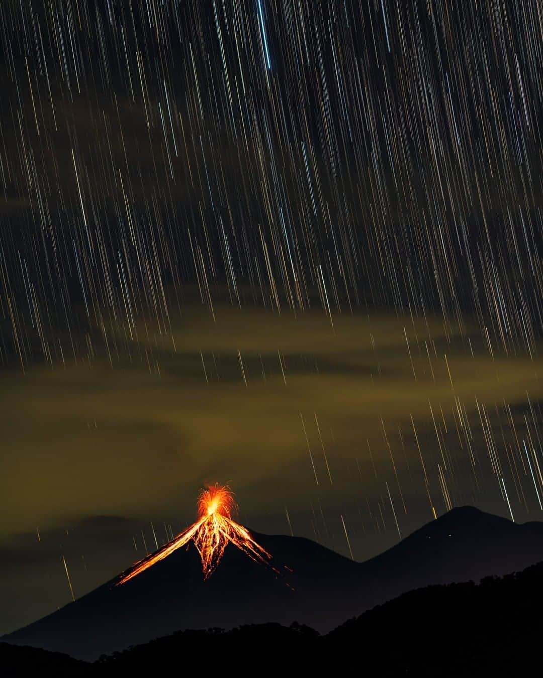 ナショナルジオグラフィックさんのインスタグラム写真 - (ナショナルジオグラフィックInstagram)「Photo by @babaktafreshi | With Earth's rotation, stars appear to rain down on the Volcán de Fuego (fire volcano), in Guatemala. The long exposure is the result of a timelapse sequence. On this November 2019 night, I recorded an average of 10 explosions per hour, with incandescent ejecta rising several hundred meters above the summit. Located only 11 miles (18k) from the World Heritage city of Antigua, it has been continuously active since a catastrophic eruption on June 3, 2018, which affected almost two million people, including  hundreds of fatalities in the nearby villages. Many bodies are still missing. ⁣ ⁣According to the U.S. Geological Survey, on that day instead of slow-moving lava, Fuego erupted with a mix of ash, rock, and volcanic gases—a rapid pyroclastic flow that surprised the villagers who were used to frequent minor eruptions. The flows raced down at speeds as high as 450 miles an hour, engulfing whole villages at the bottom. A similar event was responsible for wiping out Pompeii, in Italy, about 2,000 years ago. ⁣ #twanight #volcano #guatemala #longexposure」5月24日 7時36分 - natgeo