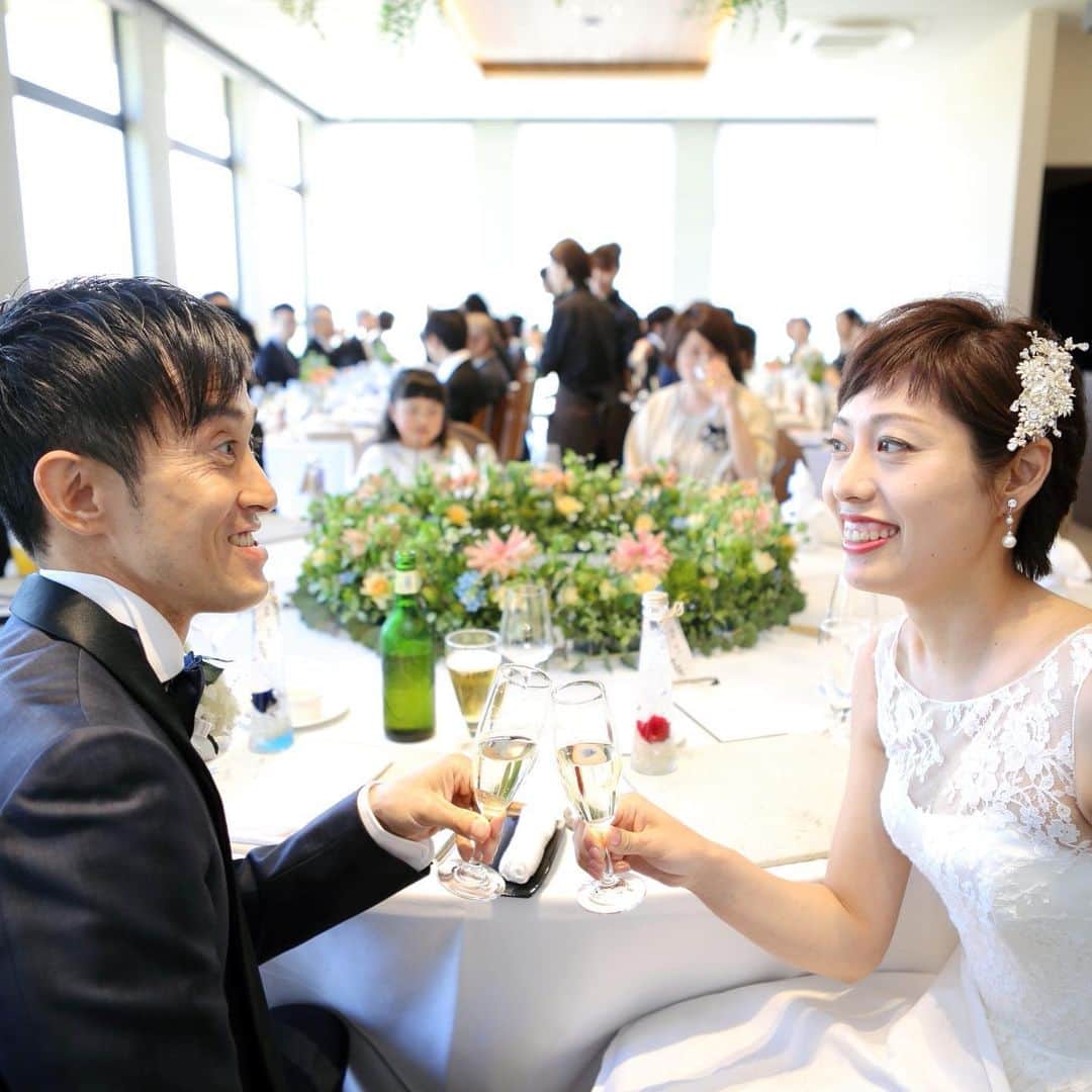 のインスタグラム：「【パーティーレポート】テーブルのお花やグリーンがとっても綺麗な、振り向き乾杯ショット♪ ﻿ ﻿ これから始まる披露宴に、ワクワクドキドキの表情を見せるお二人でした。﻿ ﻿ LOCATION : UMI no RUSTICWEDDING﻿ PARTY SPACE : LAGO BIANCO﻿ GUEST : 46﻿ SEASON : SPRING﻿ ﻿ M&Uの公式サイトでは、挙式・披露会陰会場のご紹介やパーティーレポート、最新の情報などをご確認いただけます。﻿ ﻿ プロフィール( @mandu_wedding )内にあるURLよりご確認ください。﻿ ﻿ *・。*・。*・。*・。*・。*・。*・。﻿ ﻿ 【苔の里・木場潟を巡る♪ 杜と湖のラスティックウエディング見学会】﻿ ﻿ 南加賀の大自然を舞台とする“杜と湖のラスティックウエディング”。﻿ その舞台となる苔の里・木場潟の見学ツアーです。﻿ 実際のロケーションを体感してお二人のイメージを膨らませてください！﻿ ﻿ ○開催日／土日祝の11:00〜15:00（完全予約制）﻿ ○お問い合わせ・お申し込み／プロフィール内のリンクより公式サイトにお進みください。﻿ ﻿ *・。*・。*・。*・。*・。*・。*・。﻿ ﻿ 【M&U WEDDING の結婚式】﻿ ﻿ 100年経っても変わらないこの景色。﻿ 訪れるたび、幸せの記憶がよみがえる。﻿ ﻿ 石川県小松市。ここにある自然環境を最大限に活かした、シンプルでナチュラルな結婚式、『ラスティックウエディング』﻿ ﻿ ラスティックとは、「素朴」や「温かみ」という意味があります。﻿ 自然に囲まれて、気持ちのよい日差しを浴びながら、飾り過ぎない素の美しい世界で、大切なゲストとかけがえのない時間を過ごす。まるで映画のワンシーンのようなウエディングです。﻿ ﻿ *・。*・。*・。*・。*・。*・。*﻿」
