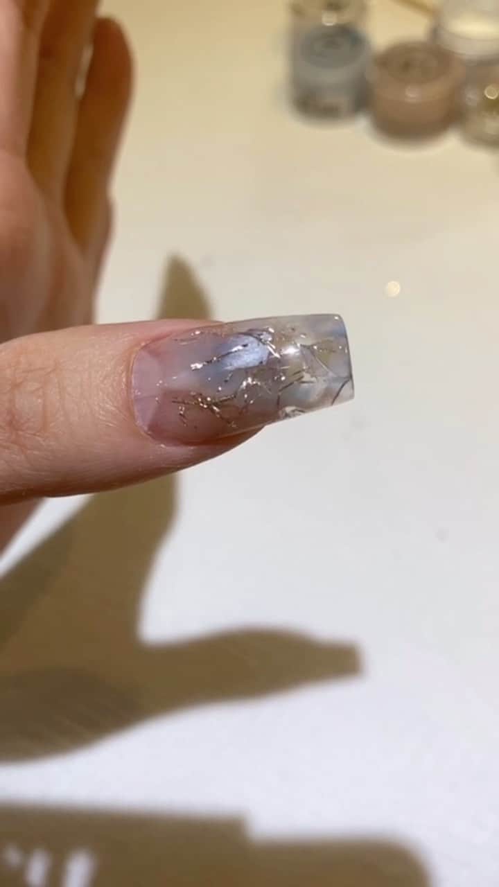 山名未紗のインスタグラム：「先日LIVEで急遽つけた親指。﻿ ご好評につき一部シェアいたします🥰﻿ LIVEの動画なのでブレブレですが参考になれば嬉しいです。 ﻿ ﻿ 【使用商材】﻿ @misa_yamana ﻿ 山名未紗プロデュース﻿ LBアクリルパウダー﻿ LB15 デニムブルー﻿ LB16 サンタンブラウン﻿ クラッシュシェル　オタグレ LB G2 グリッターとパウダーが混ざっています。 グリッターのみも販売あり クロウ　フェリーチェシルバー @misa_by_novel﻿ スパークルプリュム﻿ ↑LIVEでもふもふと呼んでいたのはこちら🤣﻿ ﻿ 【使用ブラシ】﻿ LBブルーブラシ﻿ ↑シェルやグリッターを扱うなら断然コレ！﻿ LBホワイトブラシ﻿ 万能なコリンスキー100%ブラシ﻿ LBプラスフォーム ↑ブルーの方です。サイド仕込みがなされている。  好評頂ければまたLIVEします😌コメントお待ちしています✨」