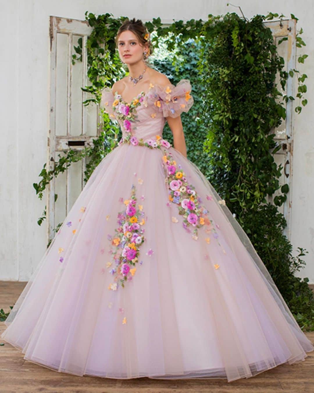 yumikatsuraのインスタグラム：「*﻿﻿﻿ 人気のプチフルールをあしらったソワレ💐﻿ ﻿ マダガスカルのヤシの葉から作られる、ラフィア刺繍で彩ったブーケ柄のインド加工をプラスした、華やかなデザイン。﻿ 天然素材らしい表情の豊かさは、高級感もあり、花嫁さまの愛らしさをたっぷり表現します♡﻿ ﻿ ベージュピンクとオレンジやパープル等色とりどりのパステルカラーを使った、他にないカラーコンビネーションと、今話題のサステナビリティを取り入れた1着で、一歩先をいくお洒落花嫁さまに✨﻿ ﻿ -------------------------﻿﻿﻿ 【AK/10055】﻿ Romantic floral gown with raffia hand embroidery﻿. Yumi Katsura continues to explore new materials,the beautiful Raffia embroidery made of palm leaves,enables the coexistence of nature and beauty,brings a sustainable style to the bridal industry. .﻿﻿﻿ .﻿﻿﻿ .﻿﻿﻿ #yumikatsura #ユミカツラ #桂由美 #桂由美ドレス #ウェディングドレス #YumiBrides #wedding #カラードレス #フォトウエディング ﻿﻿#プリンセスドレス #ロケーションフォトウェディング #ドレス迷子 #カラードレス試着 #前撮りドレス #大人婚 ﻿#ドレス試着レポ #ドレスレポ #レンタルドレス #ウエディングドレス #大人花嫁 #カラードレス迷子 #運命のドレス #プレ花嫁準備 #プレ花嫁2020 #全国のプレ花嫁さんと繋がりたい #オーダードレス #オーダードレスショップ #サステナブル #サステナブルファッション #couture」