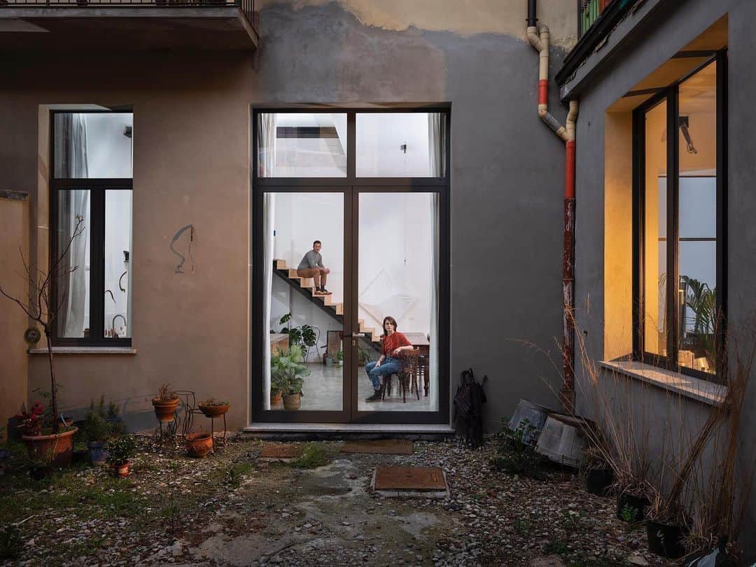 のインスタグラム：「Photo by @gabrielegalimbertiphoto | For the first two weeks of Italy's coronavirus crisis, I continued working by photographing and interviewing (together with my friend Gea Scancarello) people sequestered in their Milan homes, in compliance with the government-imposed quarantine. I left lights outside their windows, disinfecting them first. The subjects brought them in, and from outside I directed how to position them. To take these photos, we've complied with all the necessary safeguards.  Daniele Veronesi, 38, and Anna Mostosi, 33, live in a warehouse that they've transformed into a house: it is large, spacious, and beautiful, but constantly evolving. “We are two artists and set designers; we took our time, and we are continuing to do small jobs these days to take up the time,” explains Daniele.  In fact, “at the beginning, the quarantine seemed almost like a holiday, even if forced. We dedicated ourselves to our life as a couple, happily. But now, as it gets longer, the worries start." The biggest one is for Anna’s parents, who live in Bergamo, one of the areas of Italy most tormented by the epidemic: “They are, fortunately, well, and we talk to them every day. We are always in contact, but the situation is not easy,” she says. “Our fear is that we don’t know how long it will last. We agree that we all have to sacrifice, but not having the slightest foothold, or an outlook that's clear, is frightening. We greatly miss physical contact with others.” #covid19 #milan #italy #quarantine  Check out Nat Geo's link in bio for more on this story.」