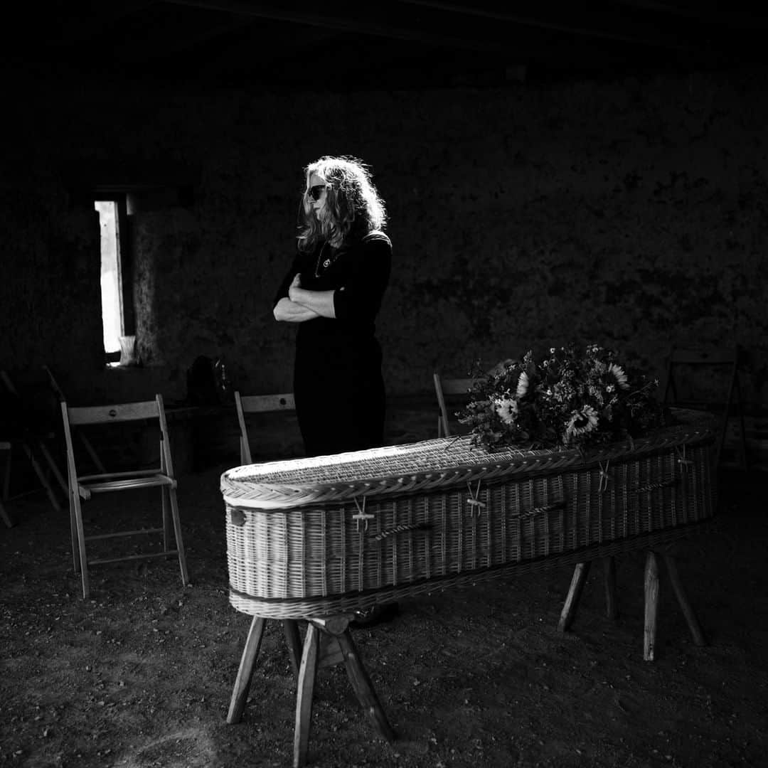のインスタグラム：「Photo by @lynseyaddario | Claire Callender, 57, is an undertaker who had to prepare her own mother’s funeral because of the COVID-19 pandemic. Here she leads a service for her mother, Rosemary Phillips, who died of natural causes at 84, at the traditional burial grounds in Totnes, England. Claire used a video call to remotely include her siblings and father in the service, as no one was able to travel due to the pandemic. The United Kingdom was one of the last in Europe to call for a nationwide lockdown to prevent large-scale deaths and illness from the coronavirus. To see more of my work follow @lynseyaddario.  Follow @natgeointhefield for real-time coverage of this developing story from photographers around the world.」