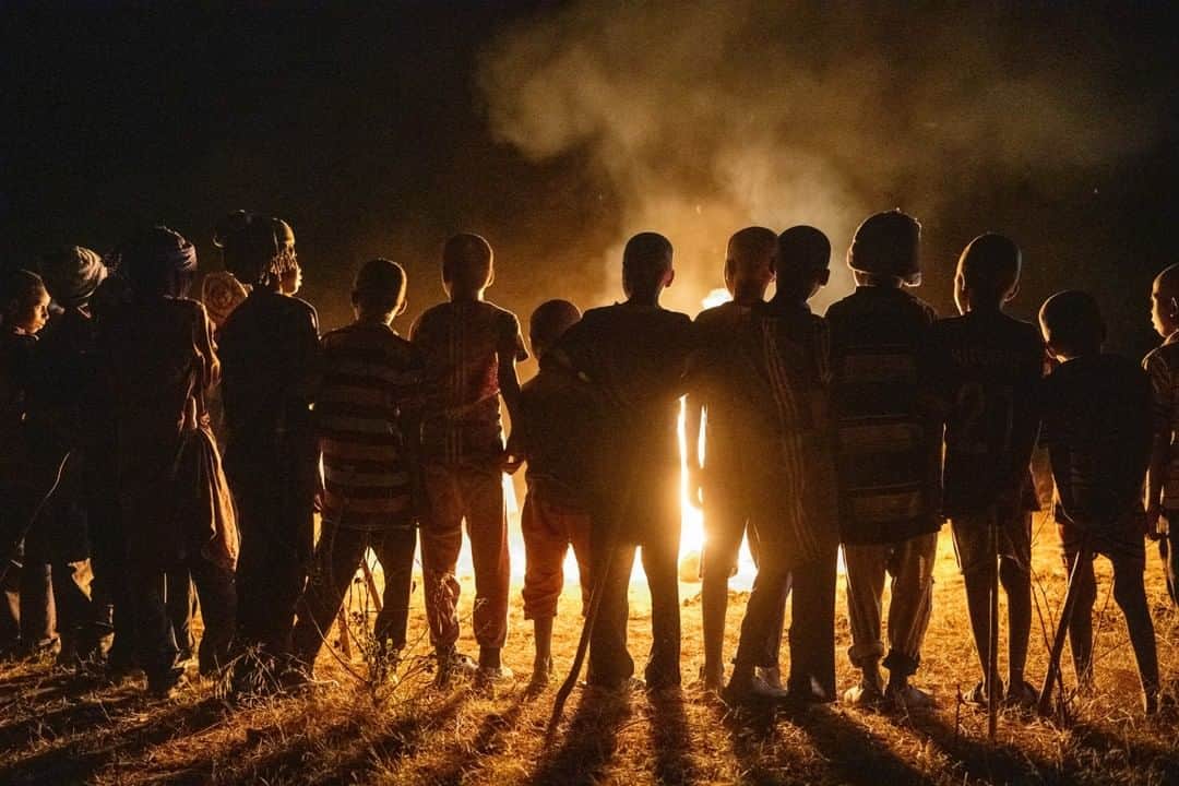 のインスタグラム：「Photo by @amivitale | Children stand around a campfire watching elders sing and dance in the village of Gouwa, about a hundred miles north of the capital N'Djamena, in Chad. There is no television, no electricity, and probably because of this, the art of storytelling, dance, and culture is an important celebration of life for the Mbororo. Nomadic pastoralists, they travel with livestock from north to south during the rainy season, following the rains. They move in groups of relatives, including children and elders, and travel on foot, donkey, or camel, staying only a few days at each stop.  I was in Chad on behalf of @rippleeffectimages, capturing the work of Hindou Oumarou Ibrahim, a member of the Mbororo community who is working to harness the centuries of wisdom and weather-predicting techniques held by the community—in order to adapt to the impacts of climate change. Follow @amivitale and @rippleeffectimages for more on climate change and those working to address it. @conservationorg @thephotosociety #climatechange #globalwarming #mbororo #indigenous #chad」