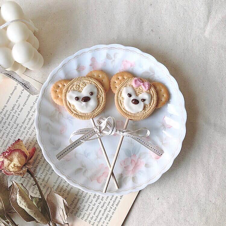 のインスタグラム：「ディズニーに行けないのが悲しい…。﻿ それならおうちでディズニー気分を味わうのはいかが？♩﻿ ﻿ ﻿ 今回ご紹介するのが、可愛らしいディズニーフードアレンジ♡﻿ ﻿ ﻿ ①かわいすぎるダフィメイサンド﻿ こちらはオレオクッキーに棒を指して、ダッフィーとシェリーメイ風にアレンジしたもの♡﻿ リボンと耳をつけるだけでこんなにかわいくなるのが凄いですね！﻿ ﻿ ﻿ ②ミッキークッキーサンドアイス﻿ こちらは実際にパーク内で販売されているアイスを再現したもの。おうちだと好きな味にアレンジすることができるため、お好みのアイスをサンドしてみては？♩﻿ ﻿ ﻿ ③ソフトクリームがミッキーに？！﻿ こちらは人気のコンビニスイーツである「ジャージー牛乳ソフト」にチョコレートを差してミッキーとミニー風にアレンジ。お耳の中のミッキーとミニーもかわいいですね♡﻿ ﻿ ﻿ ④パオまで再現できちゃう！﻿ こちらもパーク内で実際に販売されているチキンパオを再現したもの♩パンケーキ粉を使ってできるそうなのでぜひチャレンジしてみてください♡﻿ ﻿ ﻿ ディズニーに行けないさみしい気持ちは、かわいいディズニーフードで吹き飛ばしちゃいましょう！♡﻿ ﻿ ﻿ photo by﻿ @yu__paka0710﻿ @rina_annie﻿ @rie_tabi﻿ ﻿ ﻿ #isuta #イスタ #isutapic﻿ #isutacafe #おうちカフェ #おうち時間﻿ #オレオ #クッキー #サンド ﻿ #手作りお菓子 #手作りごはん #パオ ﻿ #ディズニー #disney #disneygram #mickeymouse #ミッキー ﻿ #ミニー #ダッフィー #シェリーメイ ﻿ #ジャージー牛乳 #ソフトクリーム﻿ #オレオアレンジ #ミッキーワッフル ﻿ #ディズニーランド #ディズニーシー﻿ #おかし作り #cafestagram #カフェ好き ﻿ #カフェ好きな人と繋がりたい」